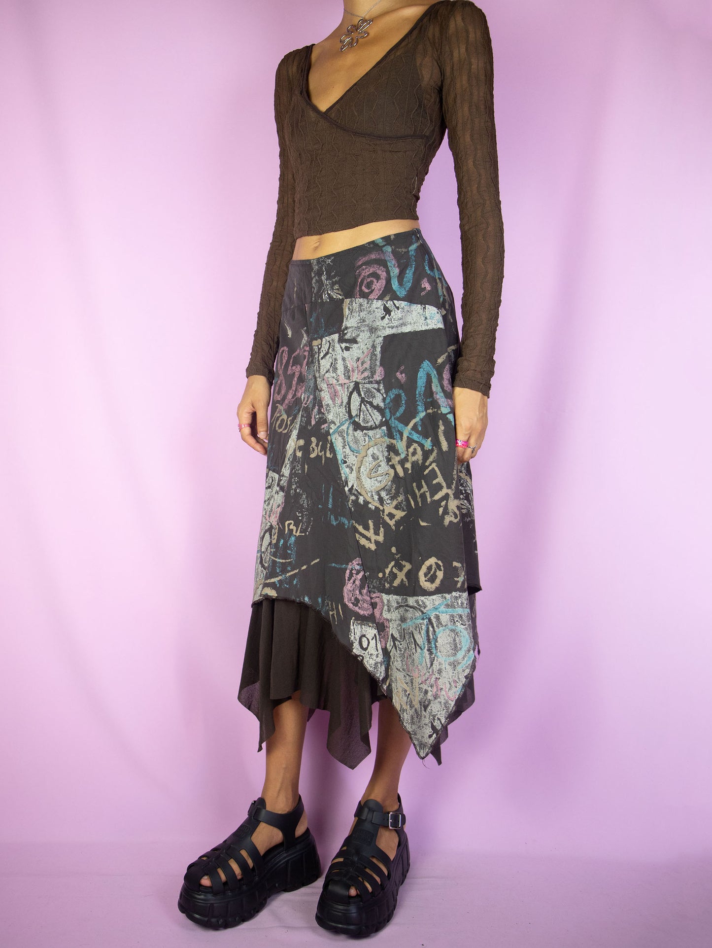 The Y2K Layered Asymmetric Midi Skirt is a vintage 2000s cyber subversive party style dark brown abstract printed skirt with a pointed asymmetrical semi-sheer mesh hem and side zipper closure. Made in France.