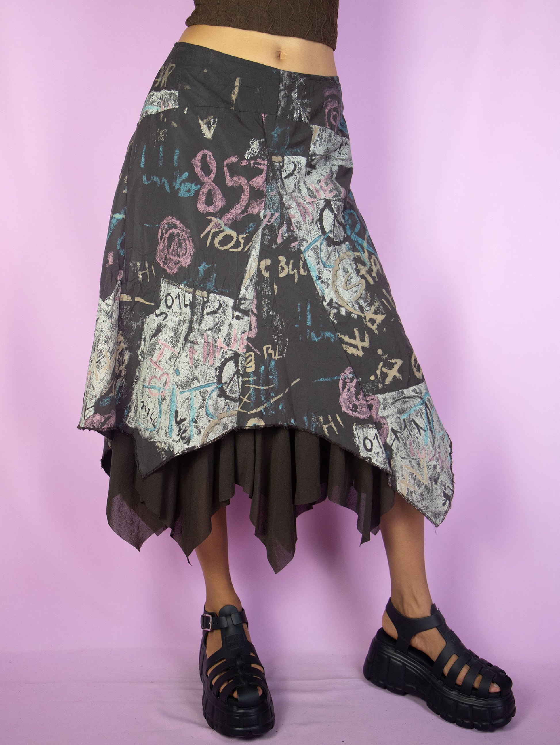 The Y2K Layered Asymmetric Midi Skirt is a vintage 2000s cyber subversive party style dark brown abstract printed skirt with a pointed asymmetrical semi-sheer mesh hem and side zipper closure. Made in France.