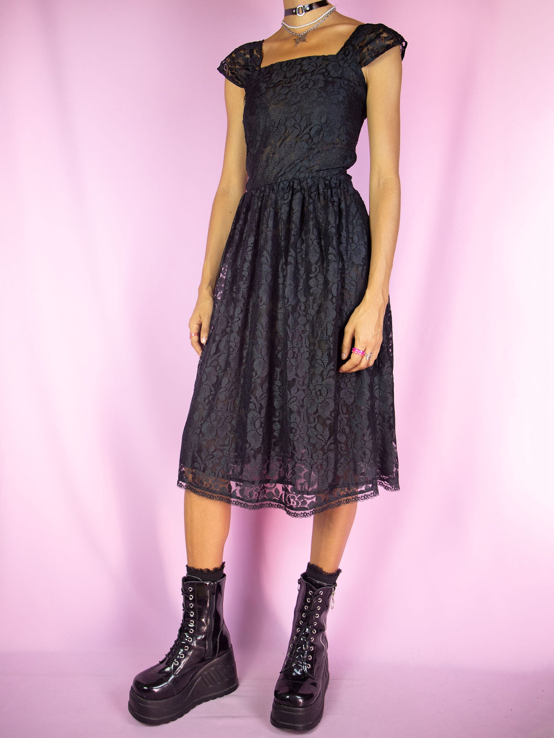 The Vintage 90s Black Lace Midi Dress is a sleeveless flare semi-sheer black lace dress with side zipper closure. Dark romantic whimsygoth 1990s party night dress.