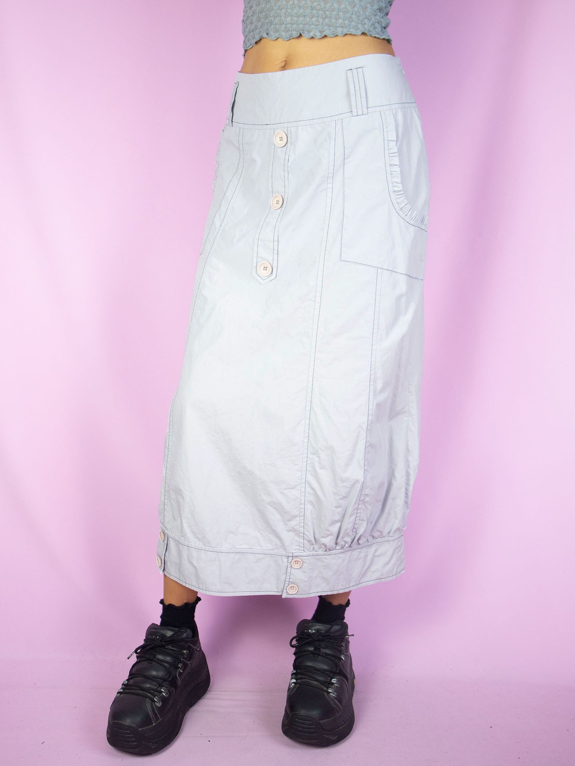 The Y2K Light Gray Midi Skirt is a vintage paneled light gray skirt with pockets and buttons and side zipper closure. Cyber goth gorpcore 2000s parachute cargo maxi skirt.