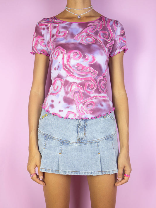 The Y2K Pink Tie Dye Top is a vintage pink and purple short sleeve t-shirt with abstract swirl tie dye print and lettuce hem. Cyber 2000s summer psychedelic graphic top.