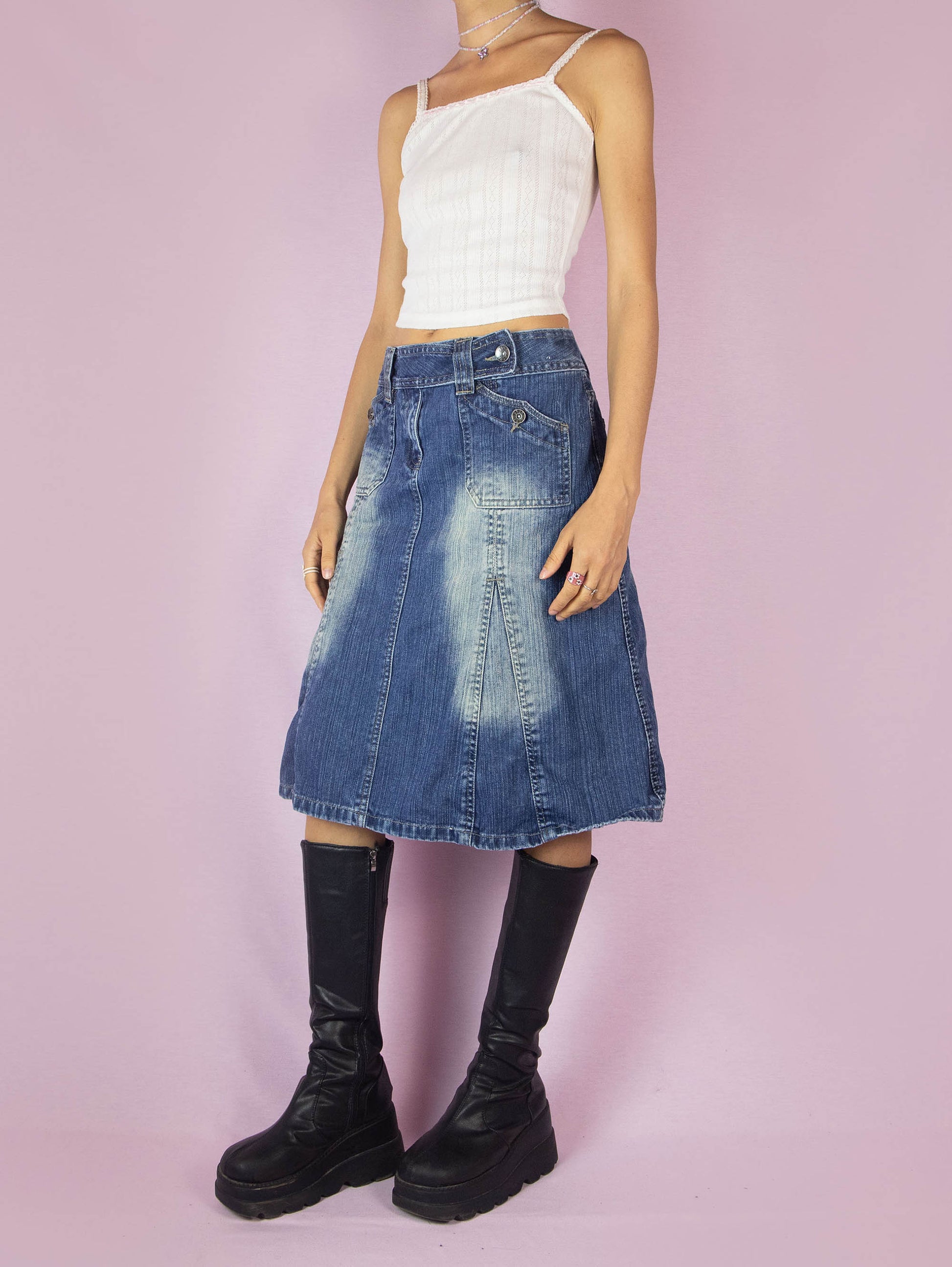 The Y2K Denim Godet A Line Skirt is a vintage 2000s subversive streetwear style jean midi skirt featuring pockets, front zipper closure, and acid wash details.