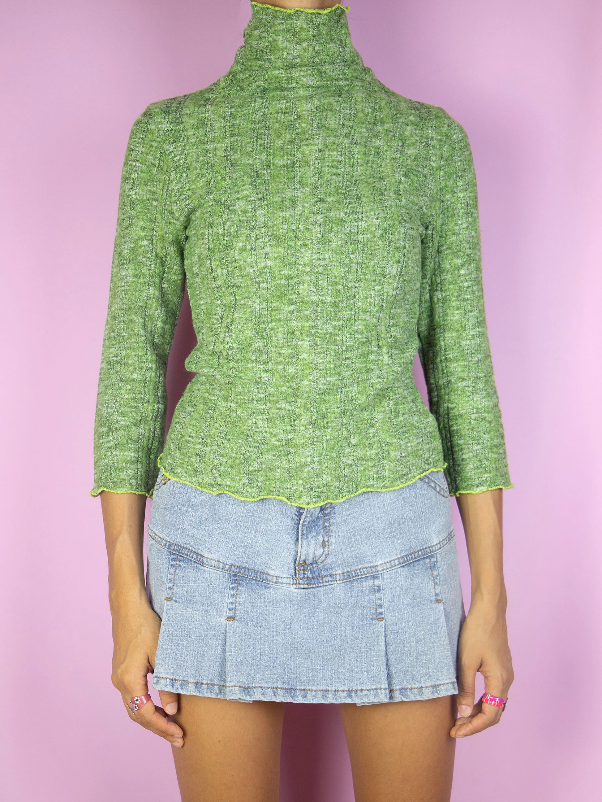 The Y2K Green Turtleneck Top is a vintage 2000s lightweight ribbed knit sweater with three-quarter sleeves.
