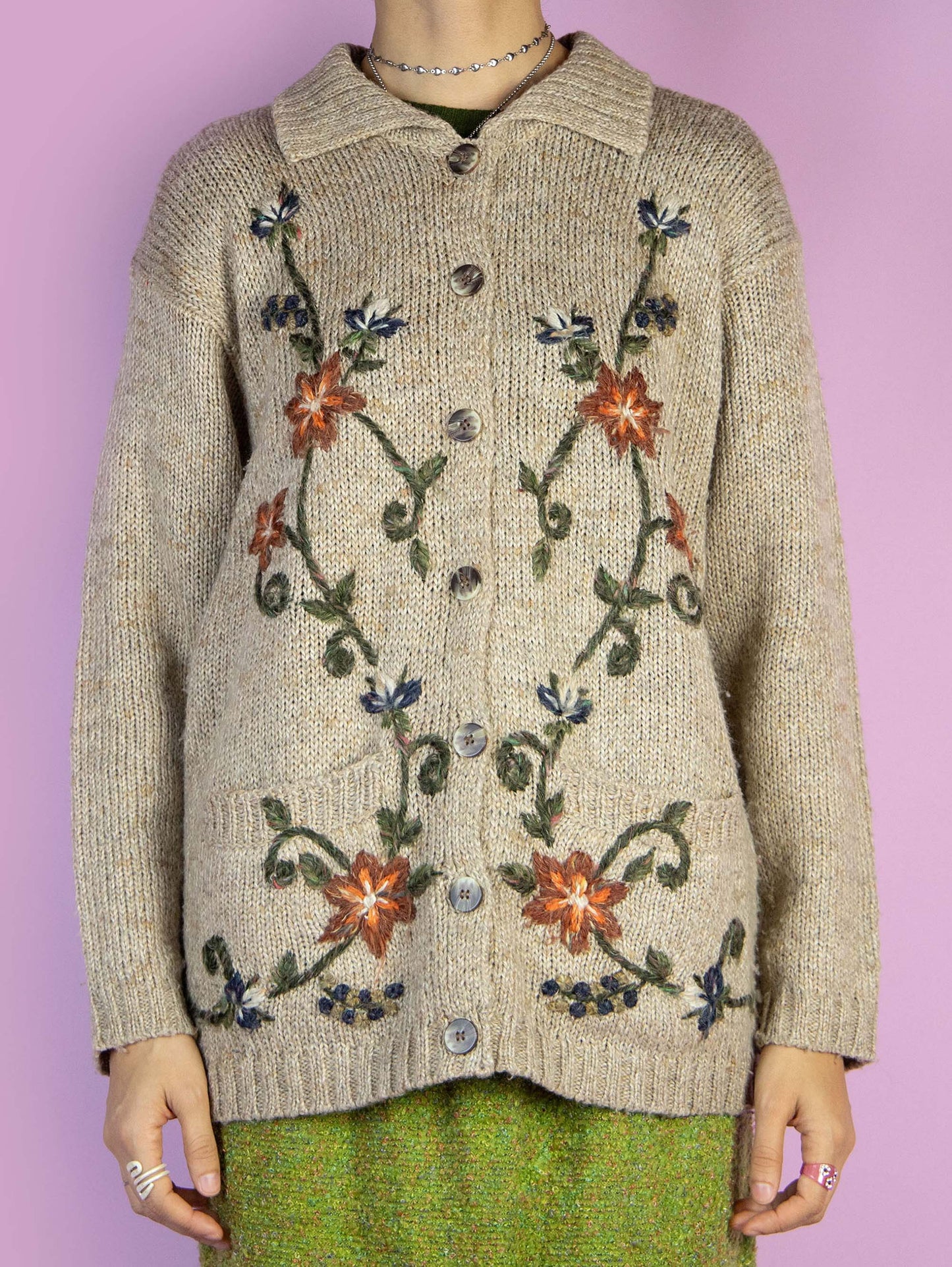 The Vintage 90s Beige Floral Knit Cardigan is a light brown beige cardigan with a collar, pockets, embroidered floral details, and button closure. Boho fairy grunge 1990s knitted sweater.