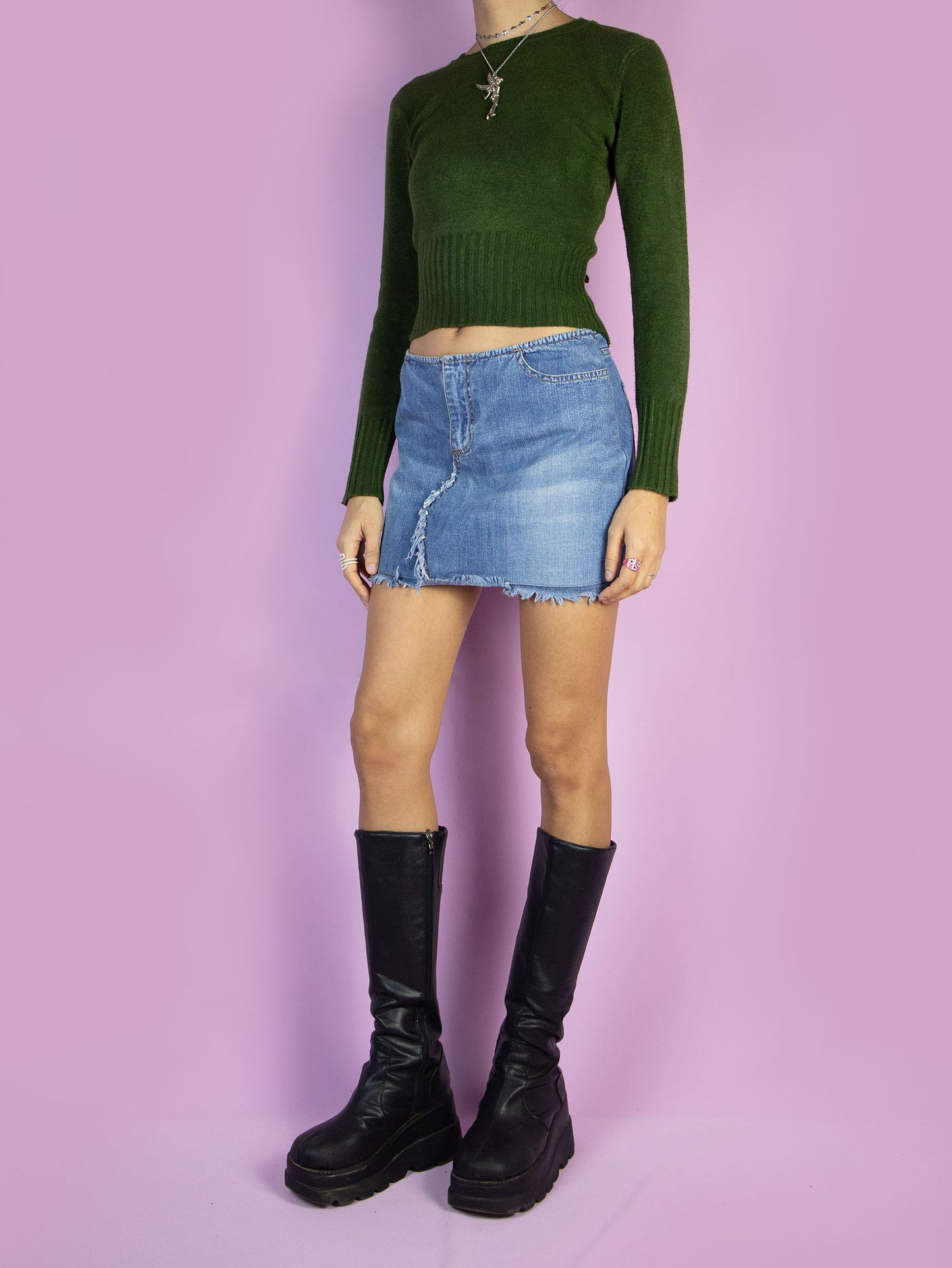 The Y2K Low Waisted Denim Mini Skirt is a vintage 2000s cyber grunge style low-rise jean mini skirt with pockets, a front zipper closure, and frayed details.