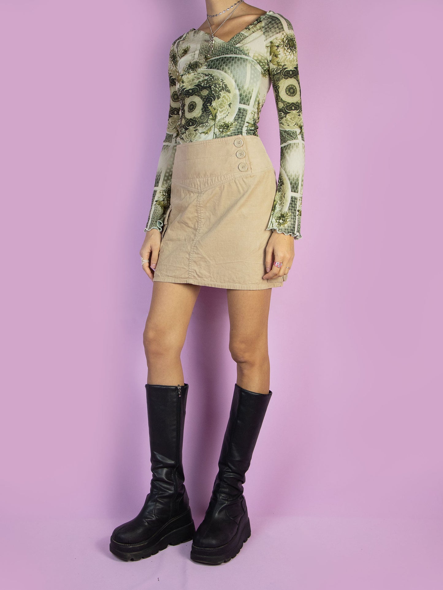 The Y2K Grunge Beige Mini Skirt is a vintage beige corduroy skirt with a pocket and a back zipper closure. Subversive utility cargo style 2000s mini skirt.