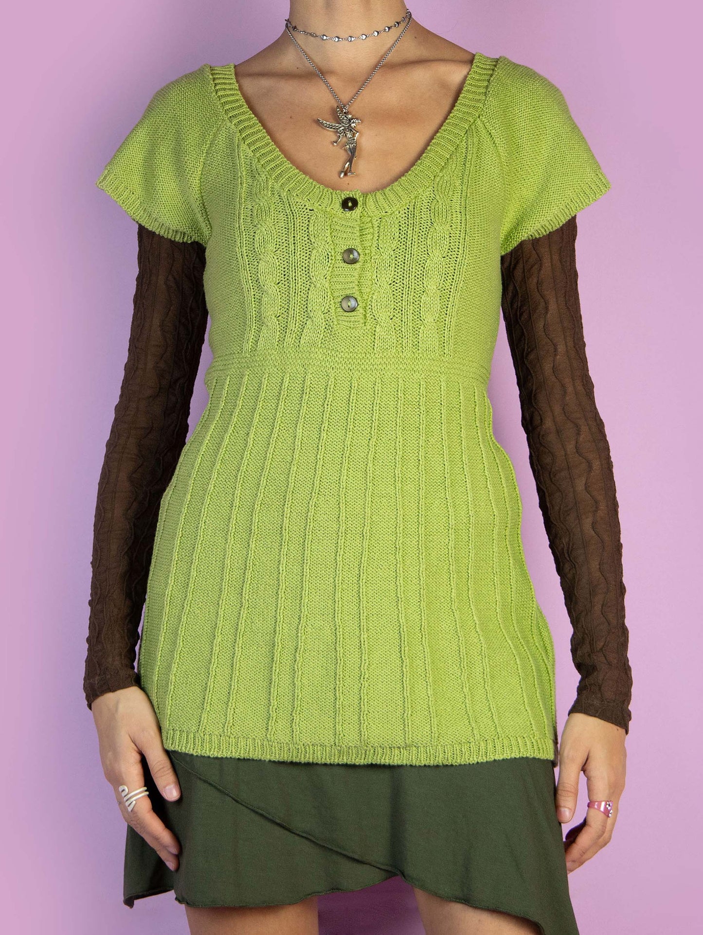 The Y2K Green Knit Top is a vintage 2000s short-sleeved green pullover sweater featuring a three-button detail. Perfect for casual fall outfits. Made in Spain.