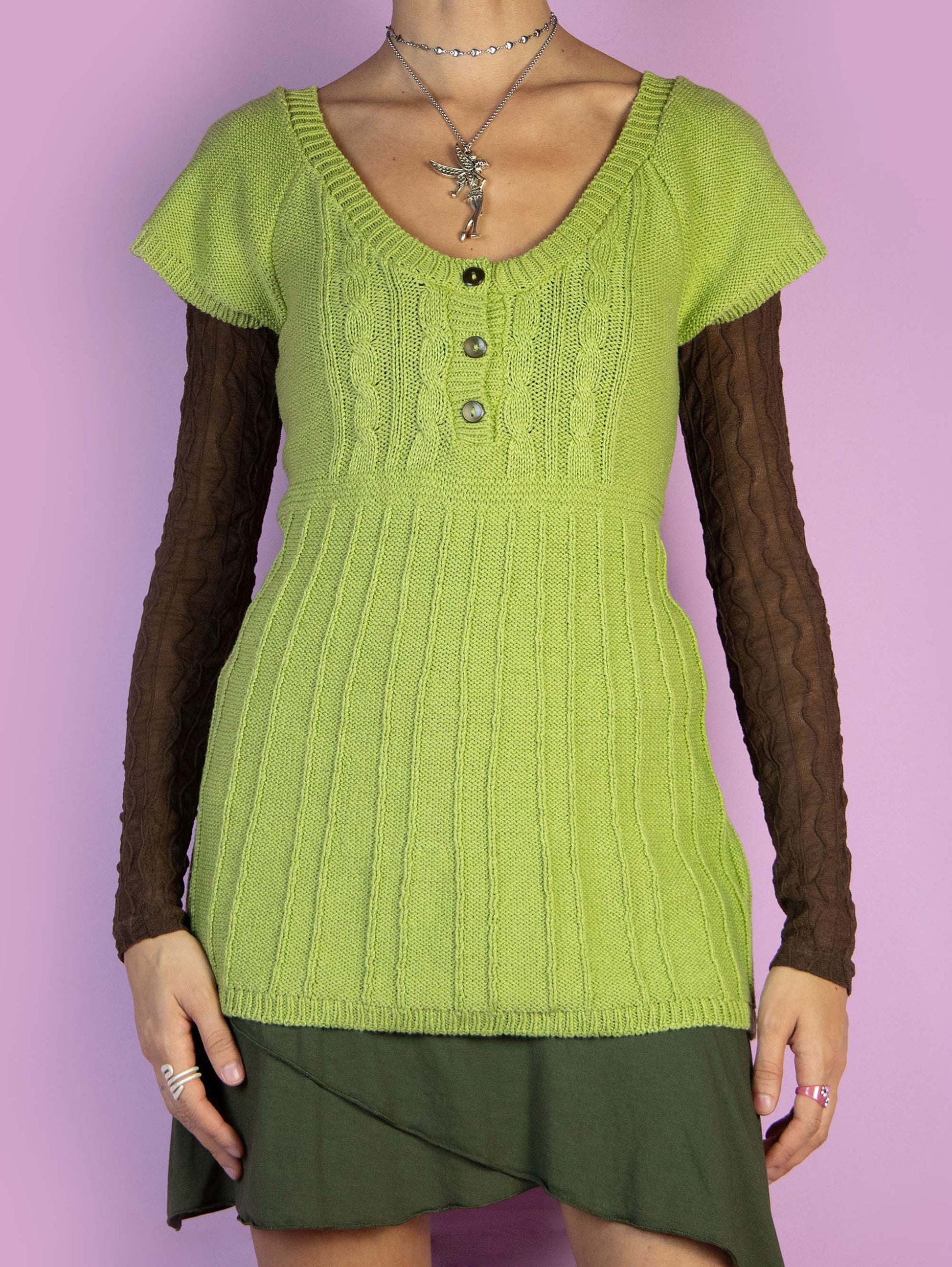 The Y2K Green Knit Top is a vintage 2000s short-sleeved green pullover sweater featuring a three-button detail. Perfect for casual fall outfits. Made in Spain.