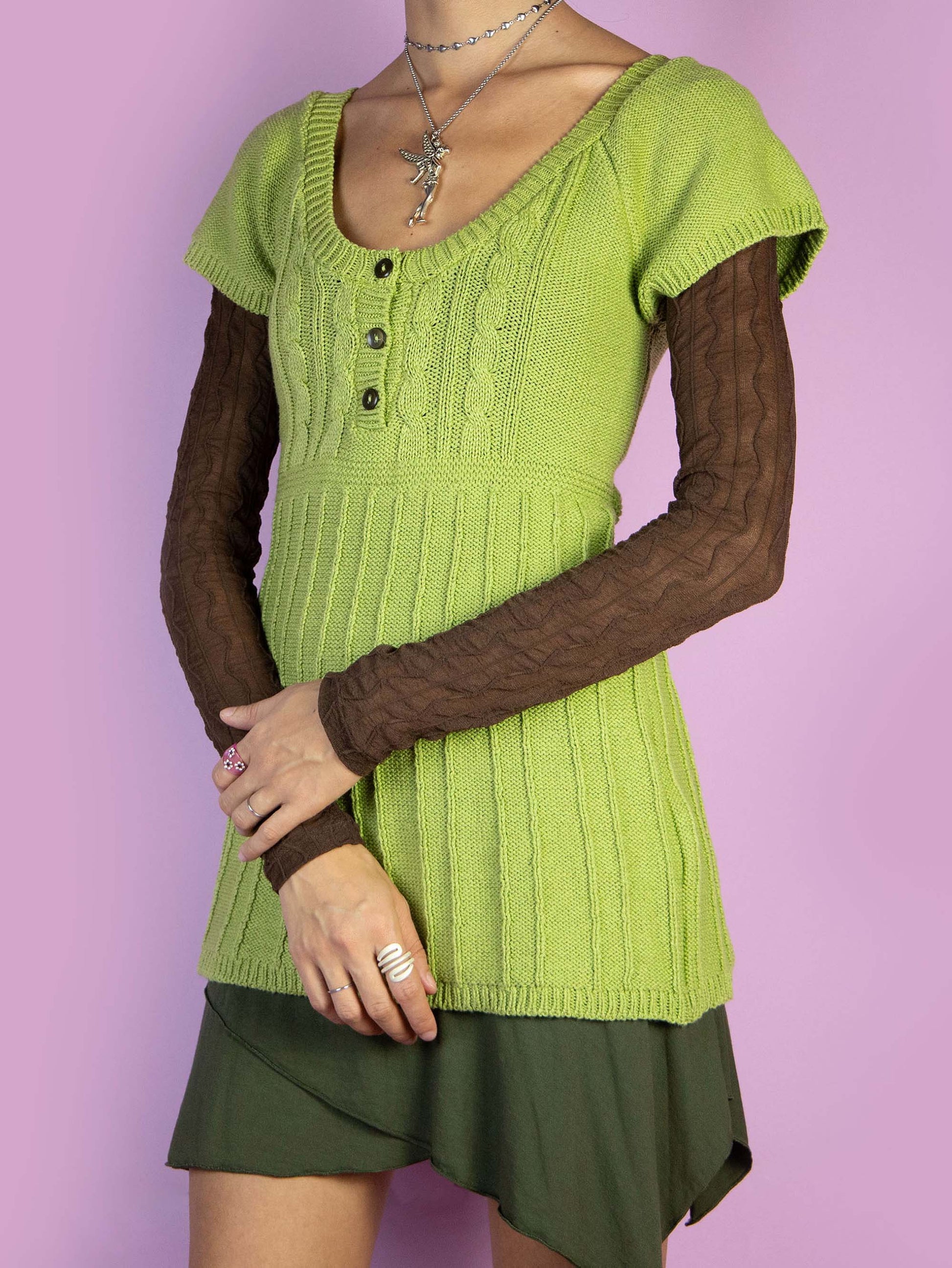 The Y2K Green Knit Top is a vintage 2000s boho style short-sleeved green pullover sweater with a three-button detail. Made in Spain.