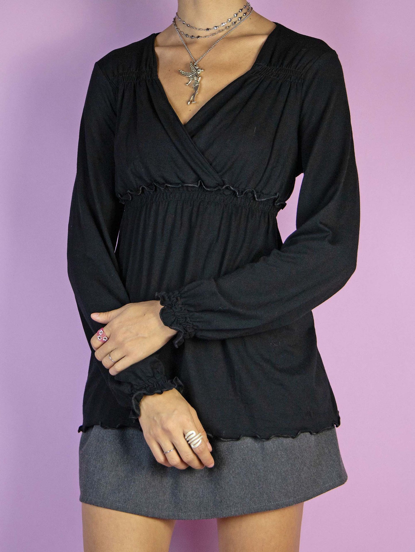The Y2K Black Shirred Waist Top is a vintage black shirt with a V-neck, elastic at the waist, and balloon sleeves. Fairy grunge whimsygoth 2000s Morgan De Toi blouse.