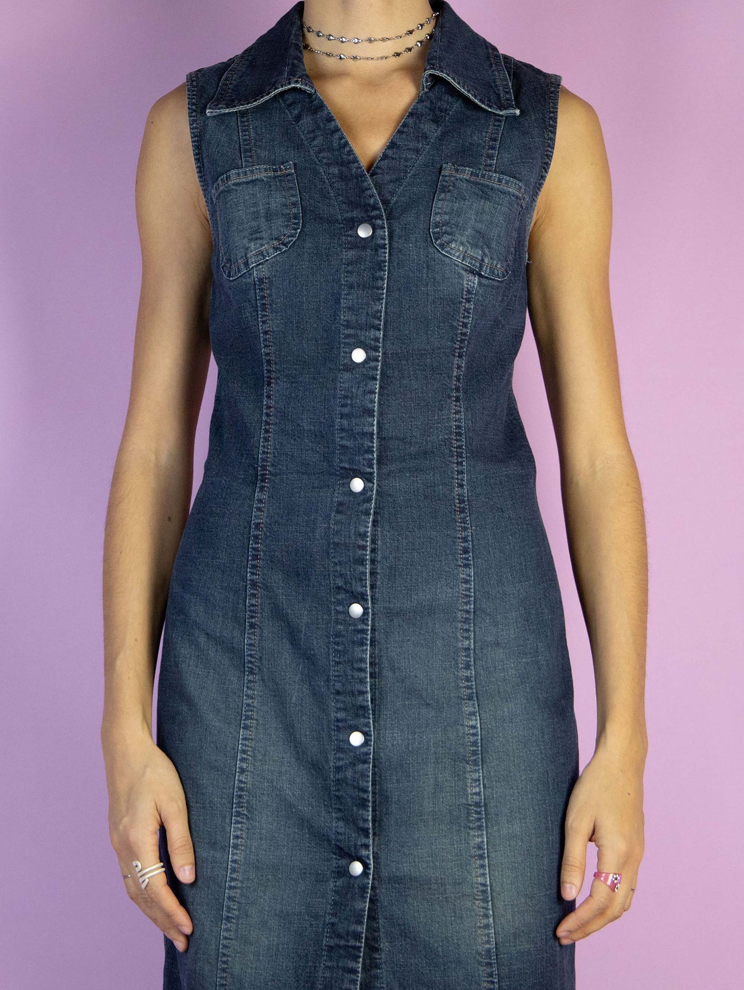 The Y2K Button Denim Midi Dress is a vintage slightly stretchy blue sleeveless dress with a collar and button closure. Cyber streetwear 2000s jean maxi dress.