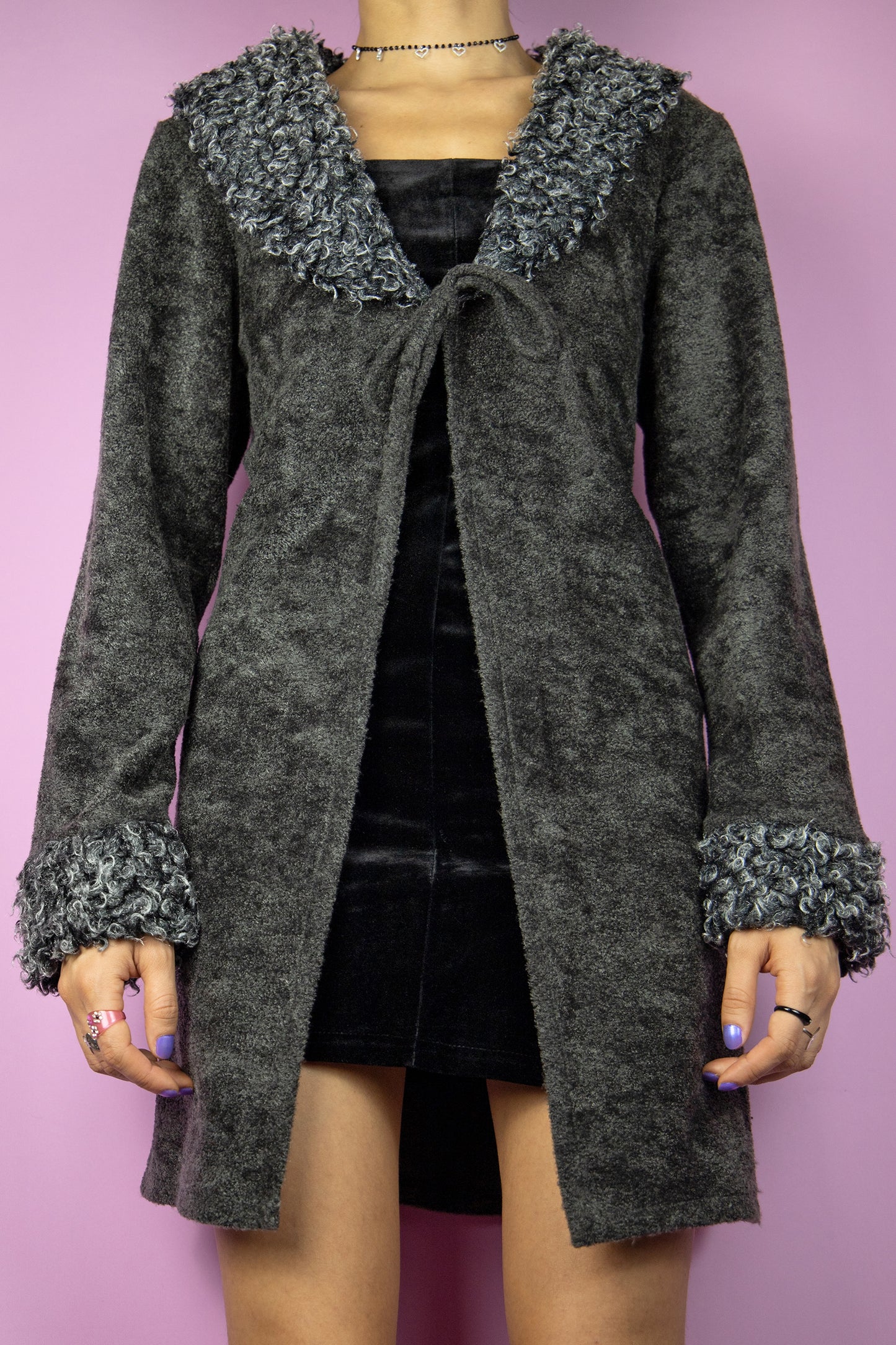The Vintage Y2K Gray Faux Fur Cardigan is a long gray jacket featuring a faux fur collar and cuffs, fastened with a tie at the front. This iconic duster jacket from the 2000s exudes cyber fashion, and it's a gorgeous statement coat reminiscent of the Penny Lane style.