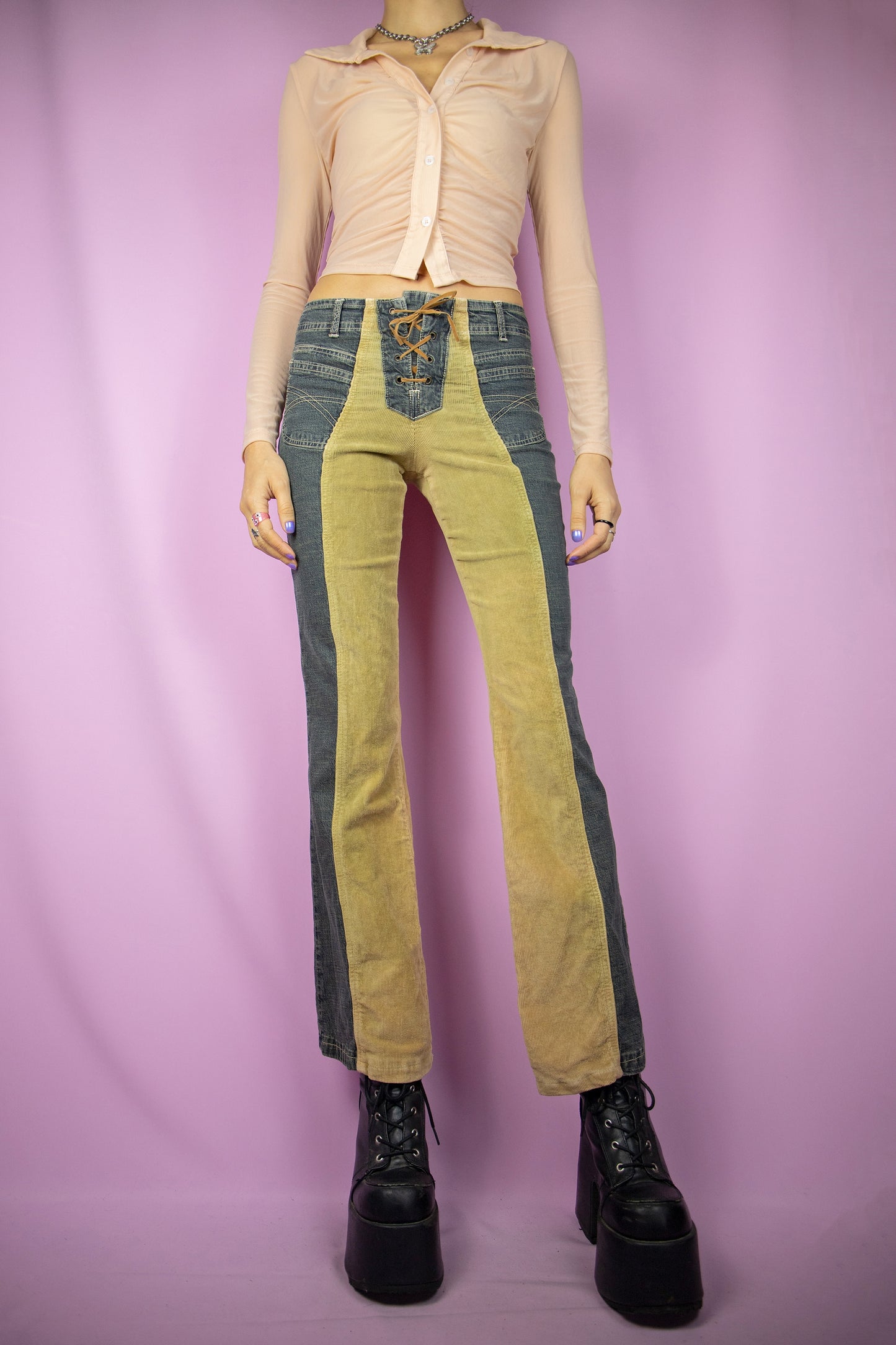 The Vintage Y2K Lace-Up Flare Jeans are mid-rise, featuring a unique design with half-denim and half-beige corduroy. These stretchy flared pants come with pockets and a tie-front detail, representing the iconic cyber millennium denim style from the 2000s.
