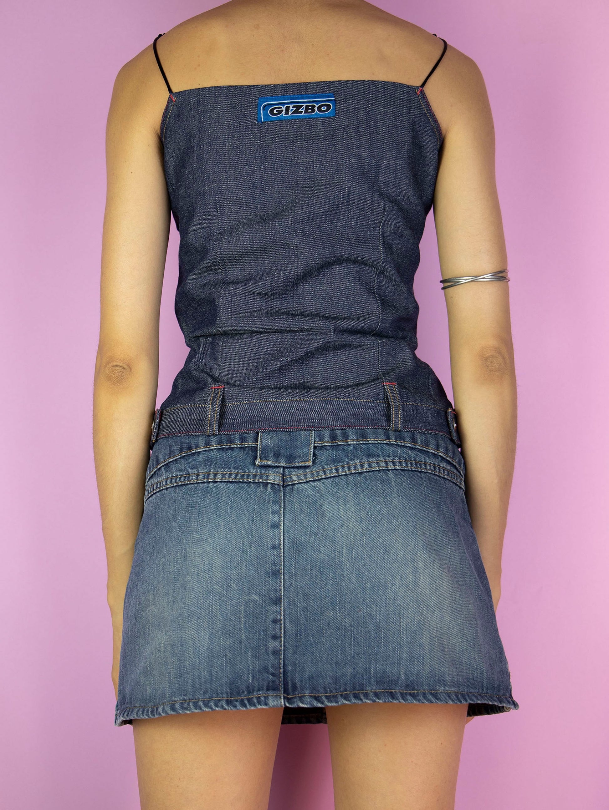 The Y2K Denim Tank Top is a vintage dark denim top with tied straps, pleats, and a side zipper closure. Cyber grunge 2000s subversive top.