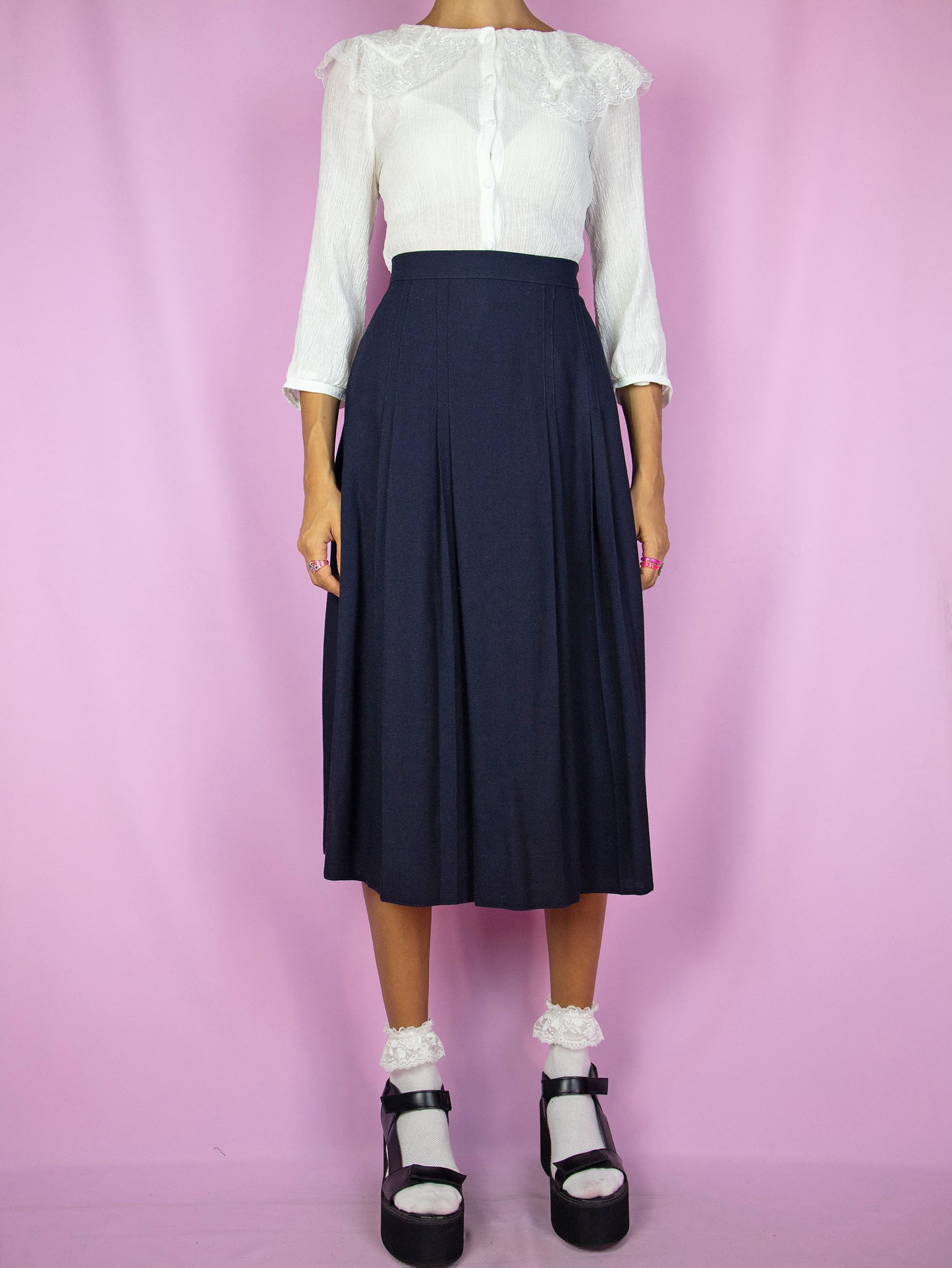 The Vintage 90s Navy Pleated Midi Skirt is a dark blue skirt with a side zipper closure. Classic preppy 1990s skirt.