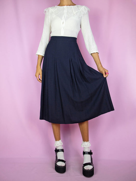 The Vintage 90's Navy Pleated Midi Skirt is a dark navy blue pleated skirt with a side zipper closure. A classic retro preppy uniform-style skirt from the 1990s.