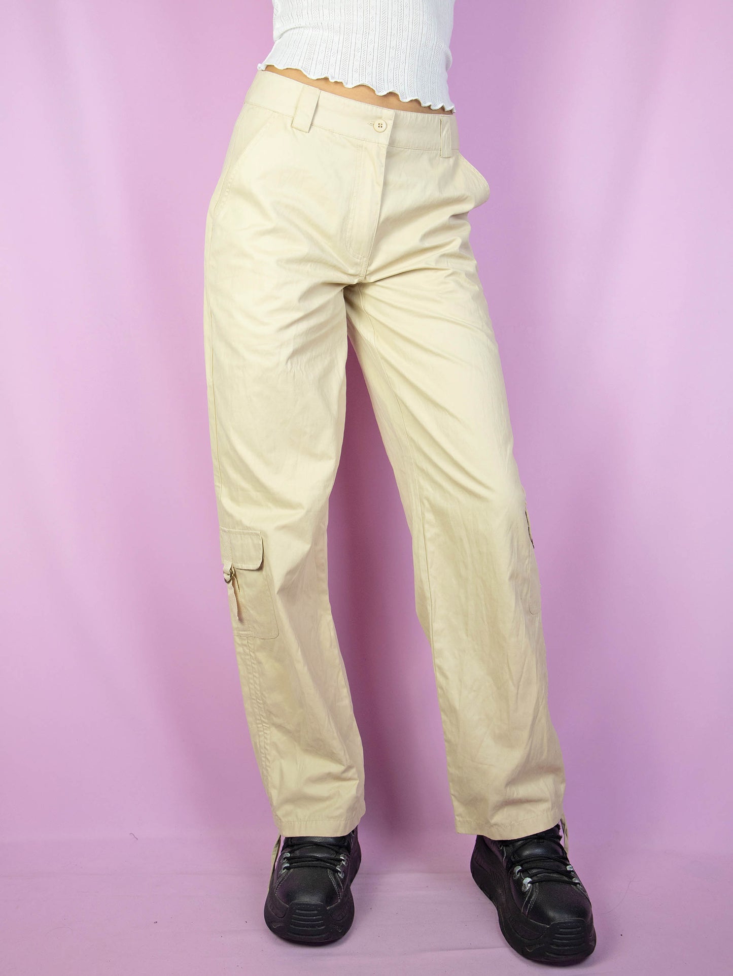The Y2K Beige Cargo Pants are vintage mid-rise wide pants with pockets and a front zipper closure. Cyber grunge 2000s utility trousers.