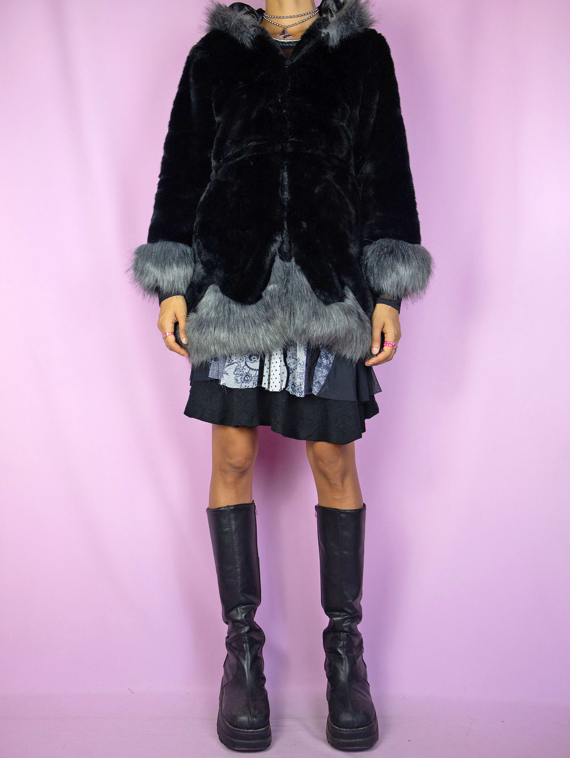 The Y2K Black Faux Fur Jacket is a vintage black faux fur jacket with gray details, a hood, pockets, and hook closure. A cute dark fairy goth winter statement coat from the 2000s.