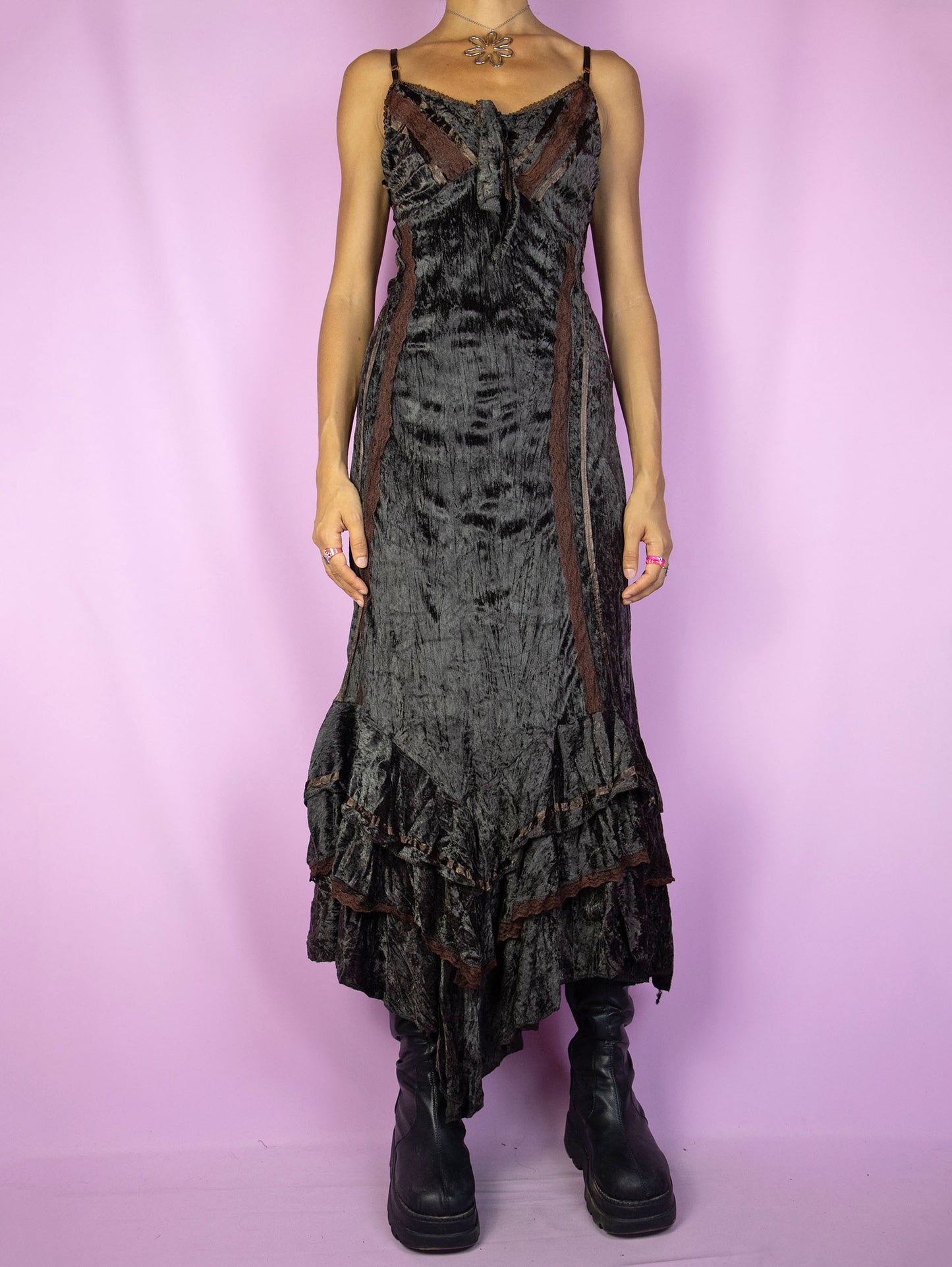 The Vintage 90s Brown Velvet Maxi Dress is a dark brown dress with adjustable straps, a tied v-neck, asymmetrical ruffled hem, lace details, and a lace-up tied back. Fairy grunge whimsygoth style 1990s evening party midi dress.