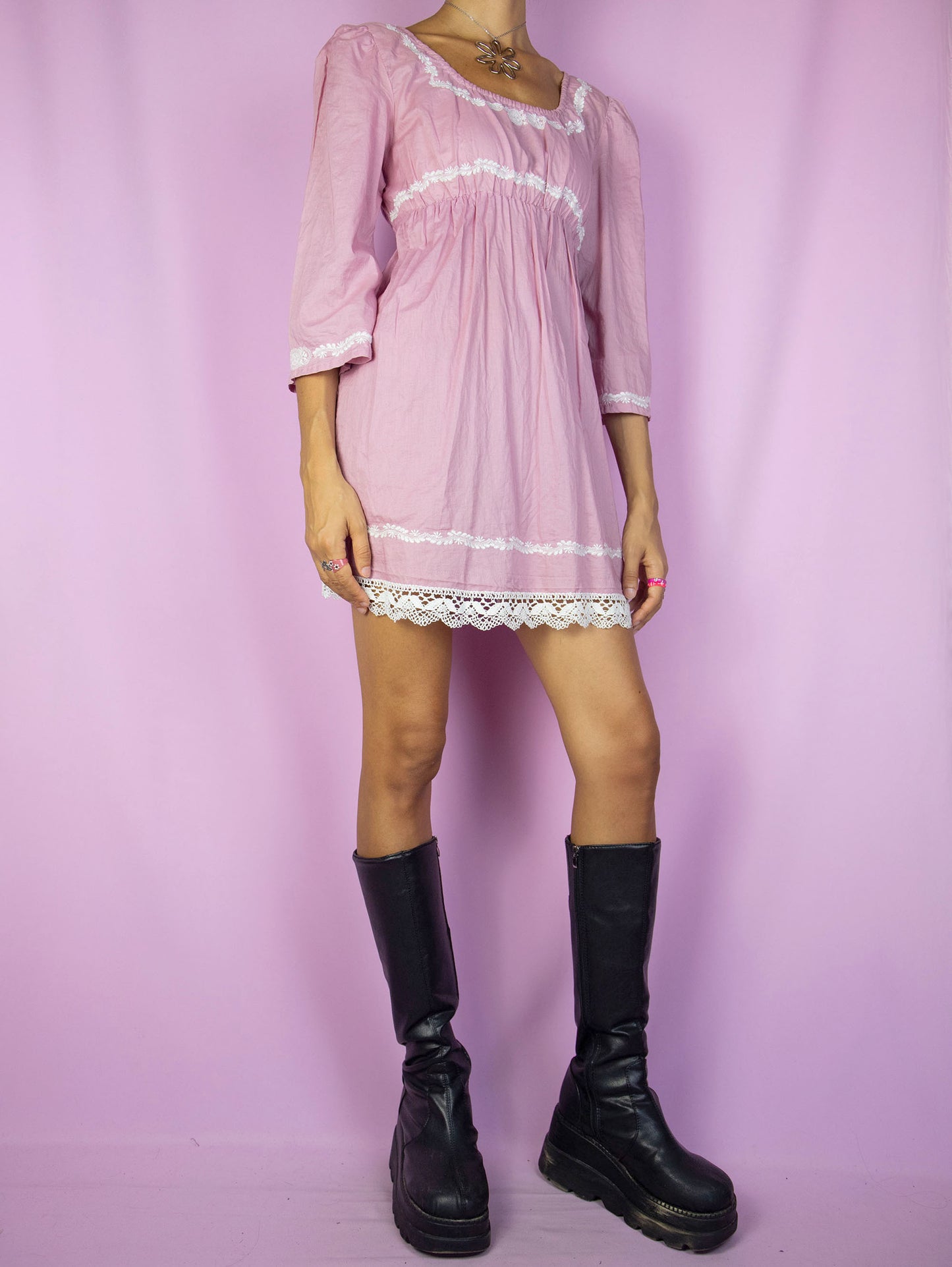 The Y2K Pink Cottage Mini Dress is a vintage dusty pink half-sleeve dress with white embroidered floral details, tied at the back. Romantic country prairie 2000s boho summer dress.