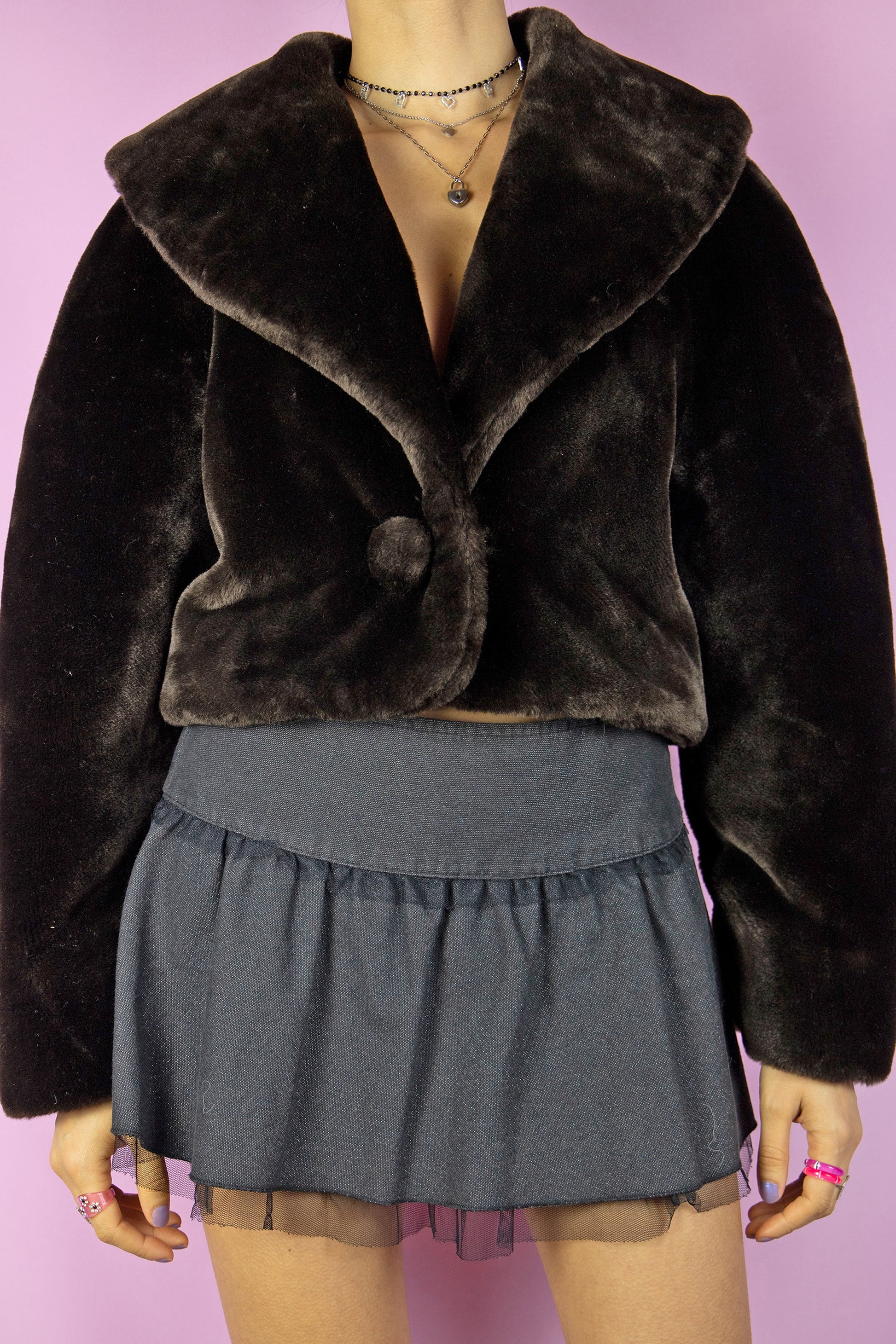 The Vintage 90s Brown Faux Fur Cropped Jacket is a dark brown winter statement bolero coat featuring a collar and a secure hook closure.