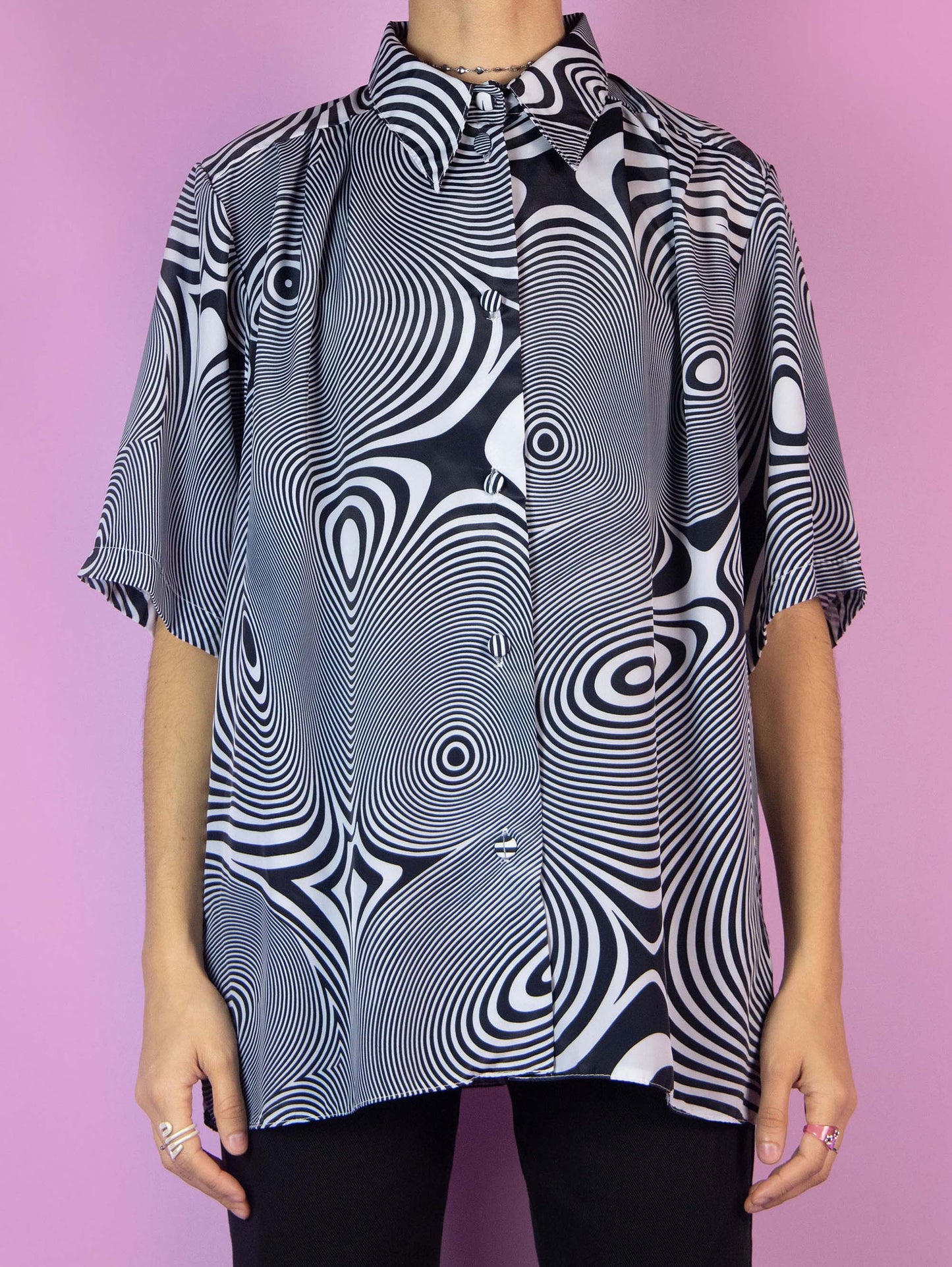 The Y2K Psychedelic Swirl Graphic Shirt is a vintage black and white short-sleeved blouse with a collar and buttons. Cyber grunge 2000s festival rave summer party shirt.