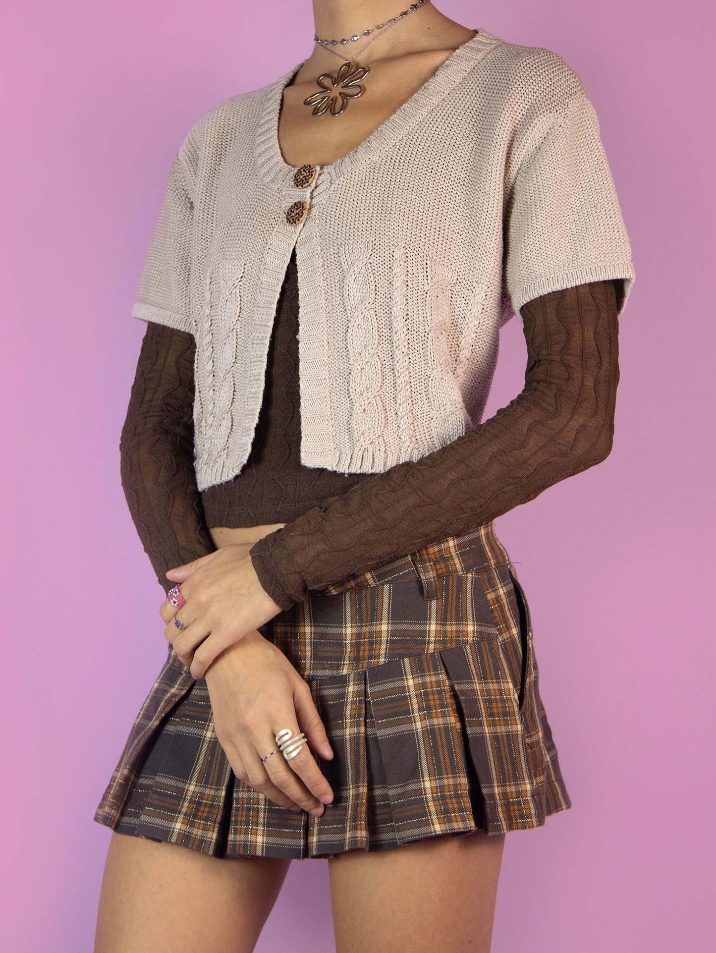 The Y2K Beige Knit Bolero Cardigan is a vintage light brown cropped bolero jacket with short sleeves and a two-button closure. Boho fairy grunge 2000s cable knit shrug.