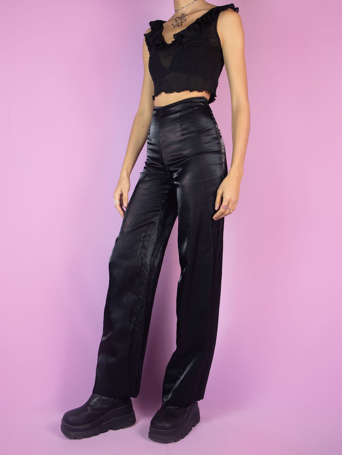 The Vintage 90s Black Tailored Wide Pants are shiny black iridescent pants with high-rise pleats, featuring a side zipper closure and wide legs. Elegant evening party 1990s classic pleated trousers.