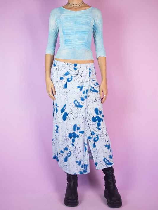 The Vintage 90s Boho Blue Wrap Skirt is a light blue midi skirt with an abstract graphic pattern, featuring a slit and an elastic waistband. Summer beach 1990s flowy cover-up maxi skirt.