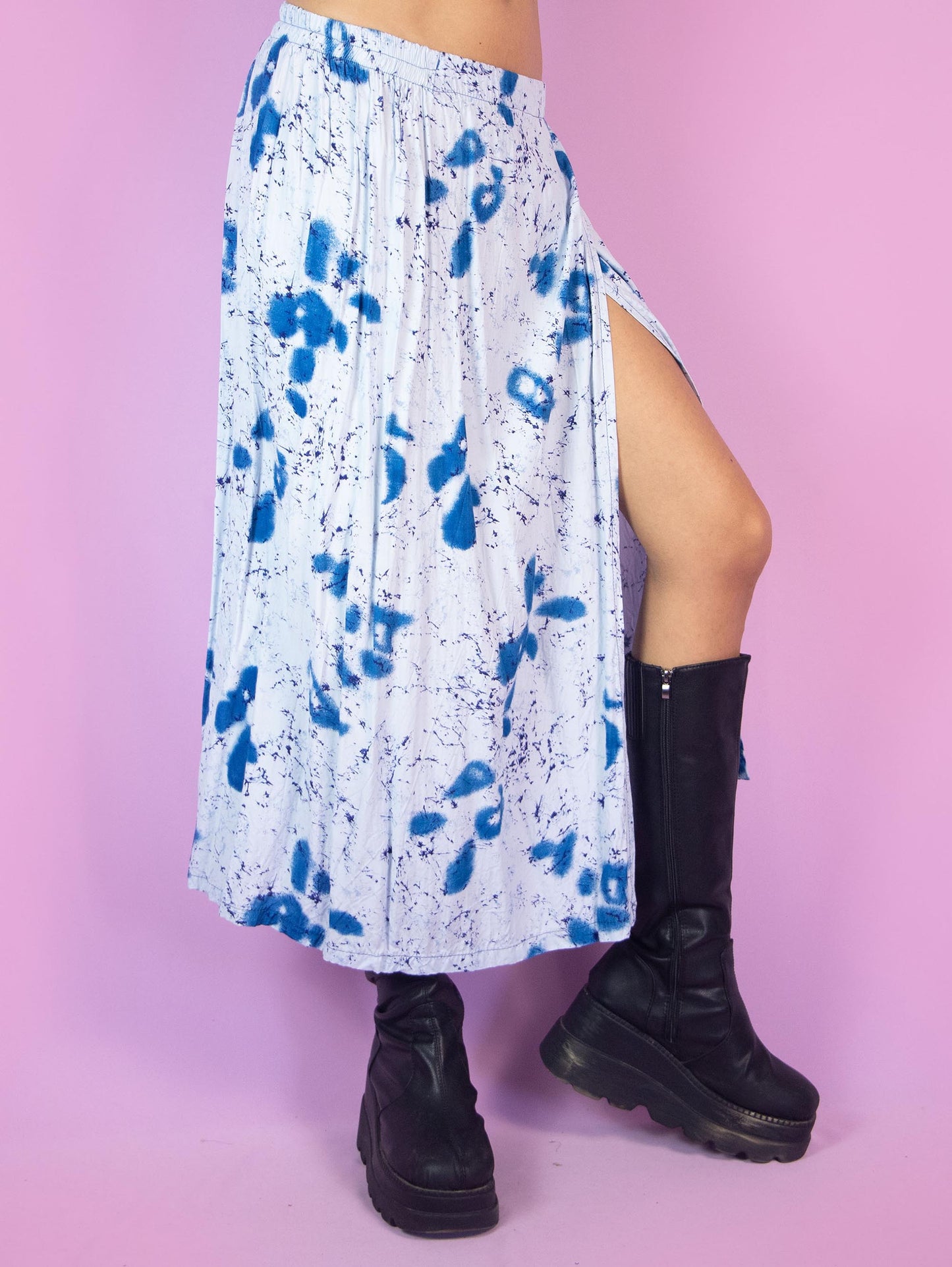 The Vintage 90s Boho Blue Wrap Skirt is a light blue midi skirt with an abstract graphic pattern, featuring a slit and an elastic waistband. Summer beach 1990s flowy cover-up maxi skirt.