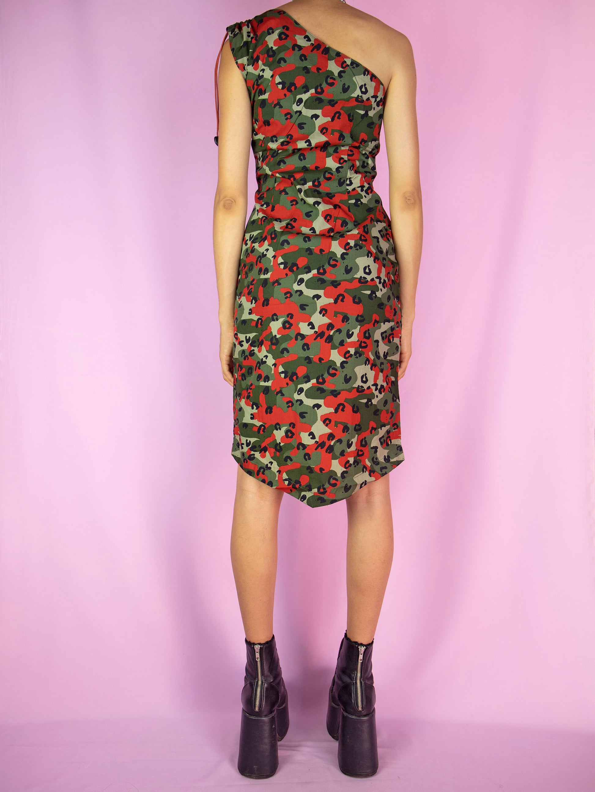 The Y2K Camouflage Print Mini Dress is a vintage red and green camo one-shoulder fitted pencil dress featuring a zippered front slit. Cyber grunge 2000s festival rave party mini dress. Excellent vintage condition.