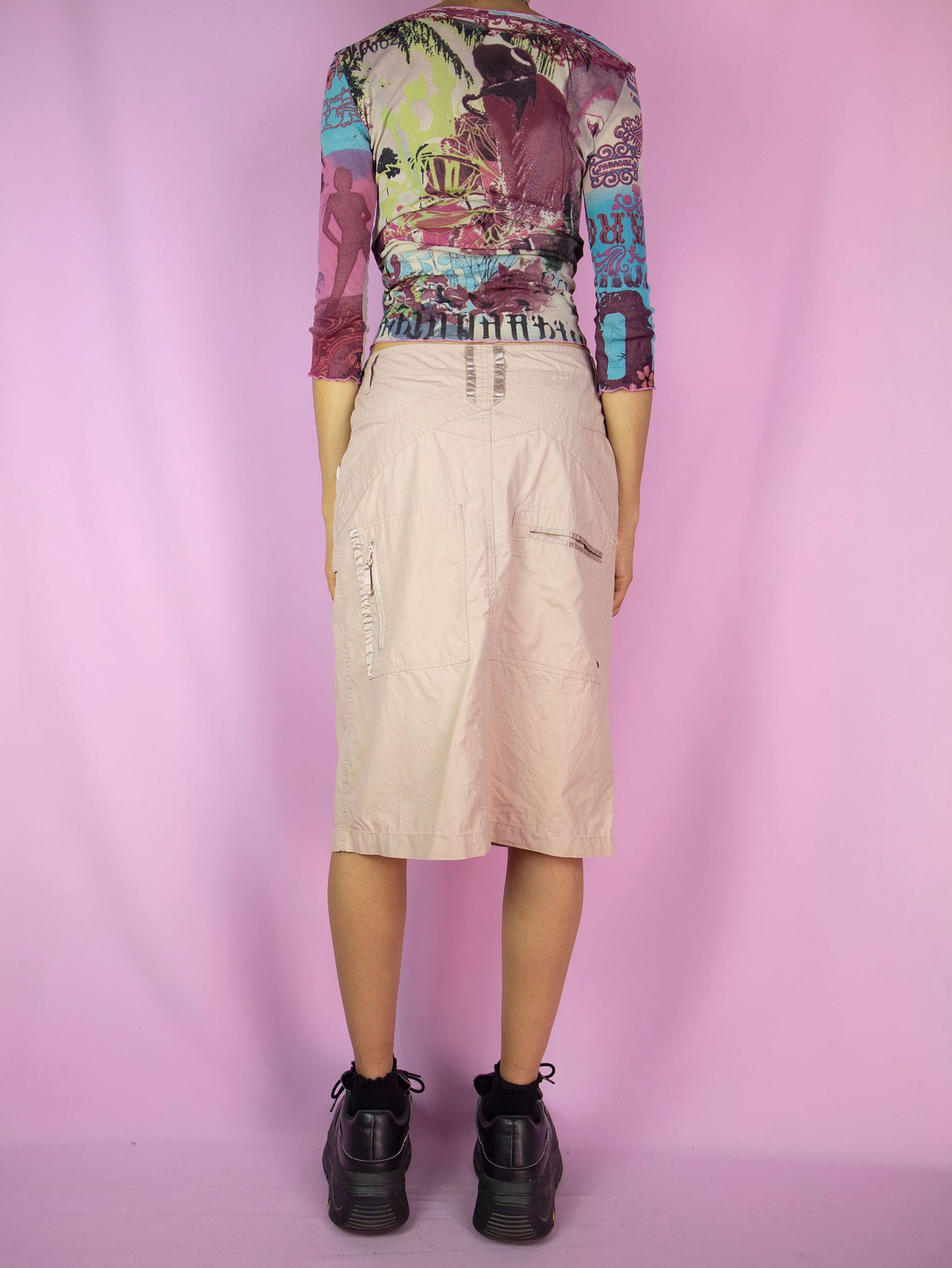 The Y2K Pink Grunge Cargo Skirt is a vintage light pink beige skirt with pockets and a front zip closure. Cyber gorpcore 2000s utility midi skirt.