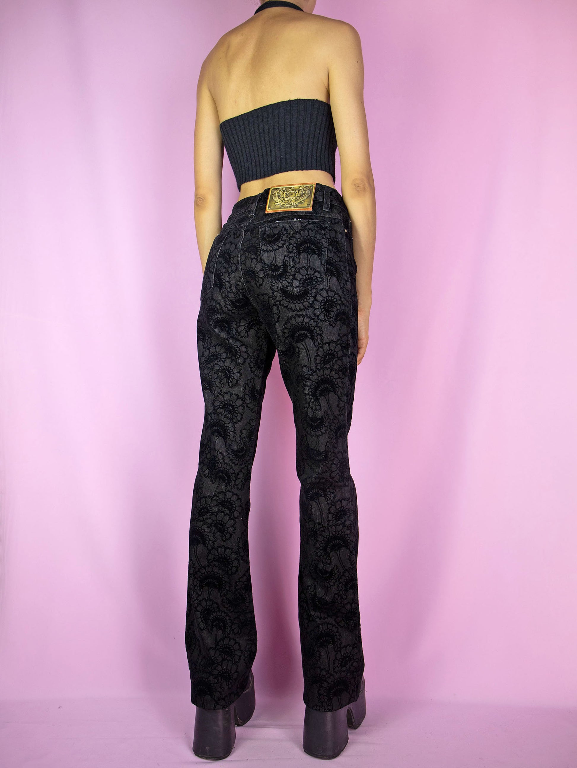 The Y2K Cavalli Black Straight Jeans are vintage 2000s mid-rise straight-leg pants, slightly stretchy adorned with floral velvet details by italian designer Roberto Cavalli. Excellent vintage condition.