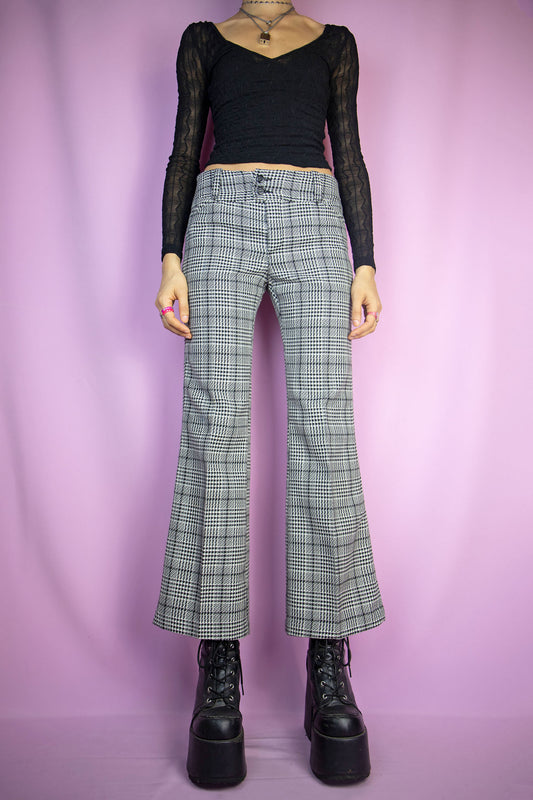 The Vintage 90's Black Plaid Flare Pants feature a black and white checkered pattern, flared legs, pockets, and a front zipper closure. These super cute classic preppy gingham knit wide trousers are from the 1990s.