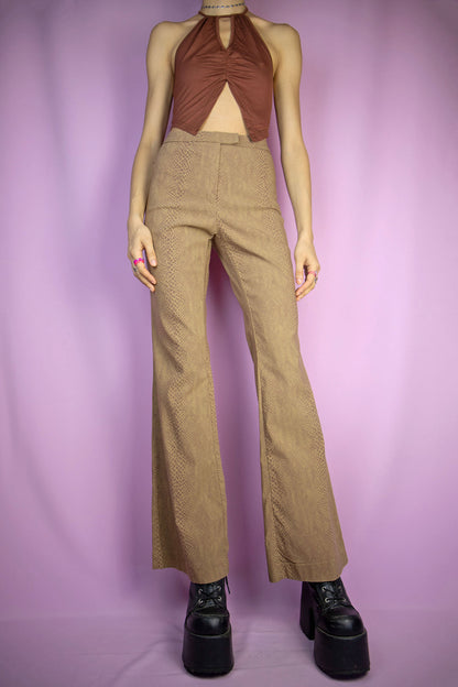 The Vintage Y2K Brown Croc Flare Pants feature a brown, stretchy fabric with a crocodile animal print and a front zipper closure. These iconic cyber party night festival trousers capture the flair of the 2000s.