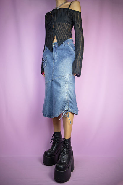 The Vintage Y2K Asymmetric Denim Midi Skirt is a stretch denim skirt featuring asymmetrical design, pockets, a flared hem, and a stylish ruched tie detail. This iconic deconstructed cyber jean maxi skirt captures the essence of the 2000s.