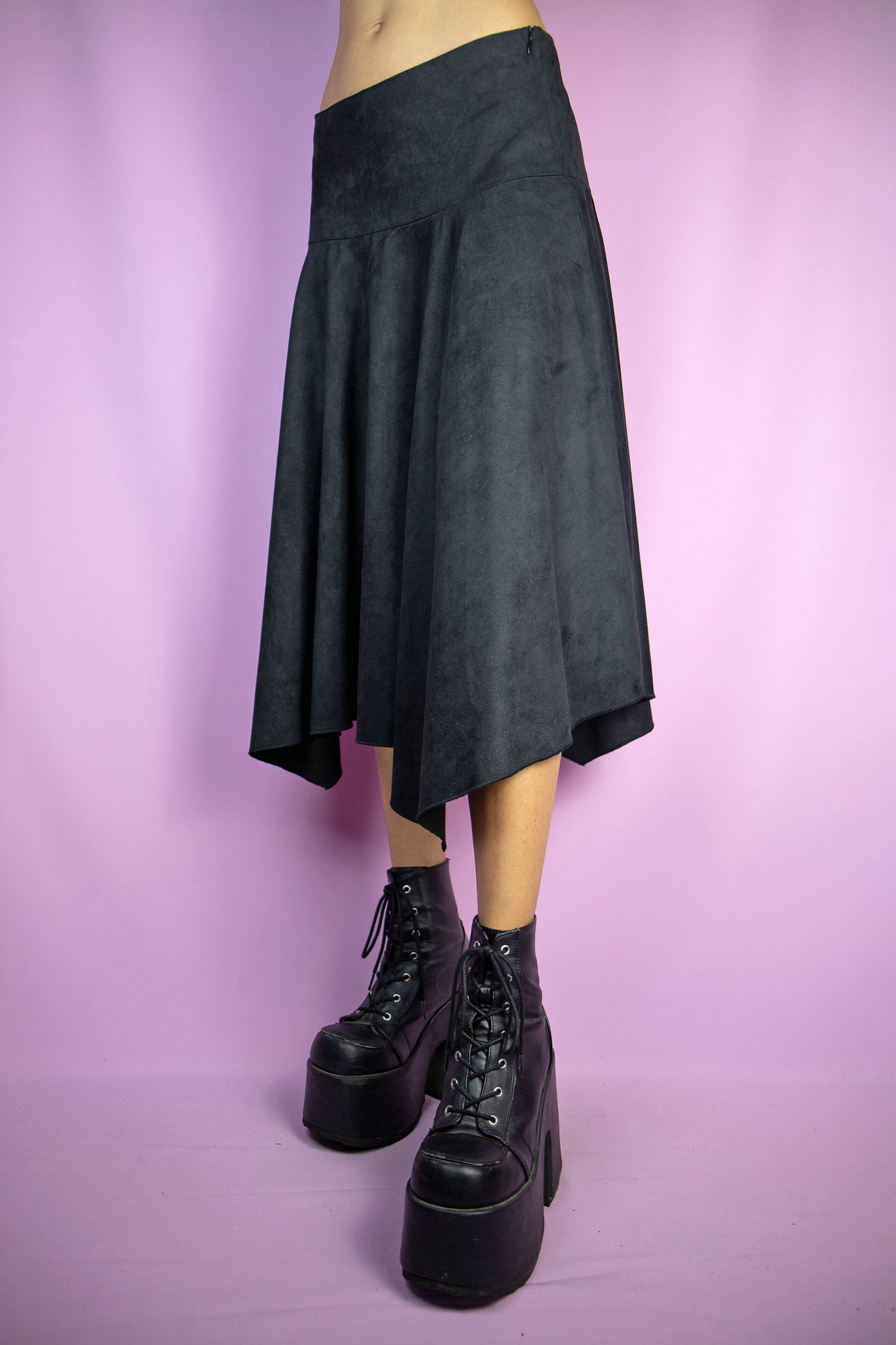 The Y2K Black Asymmetric Midi Skirt is a vintage faux suede skirt with an asymmetrical pointed hem and side zipper closure. Cyber fairy goth 2000s subversive handkerchief midi skirt. Excellent vintage condition.