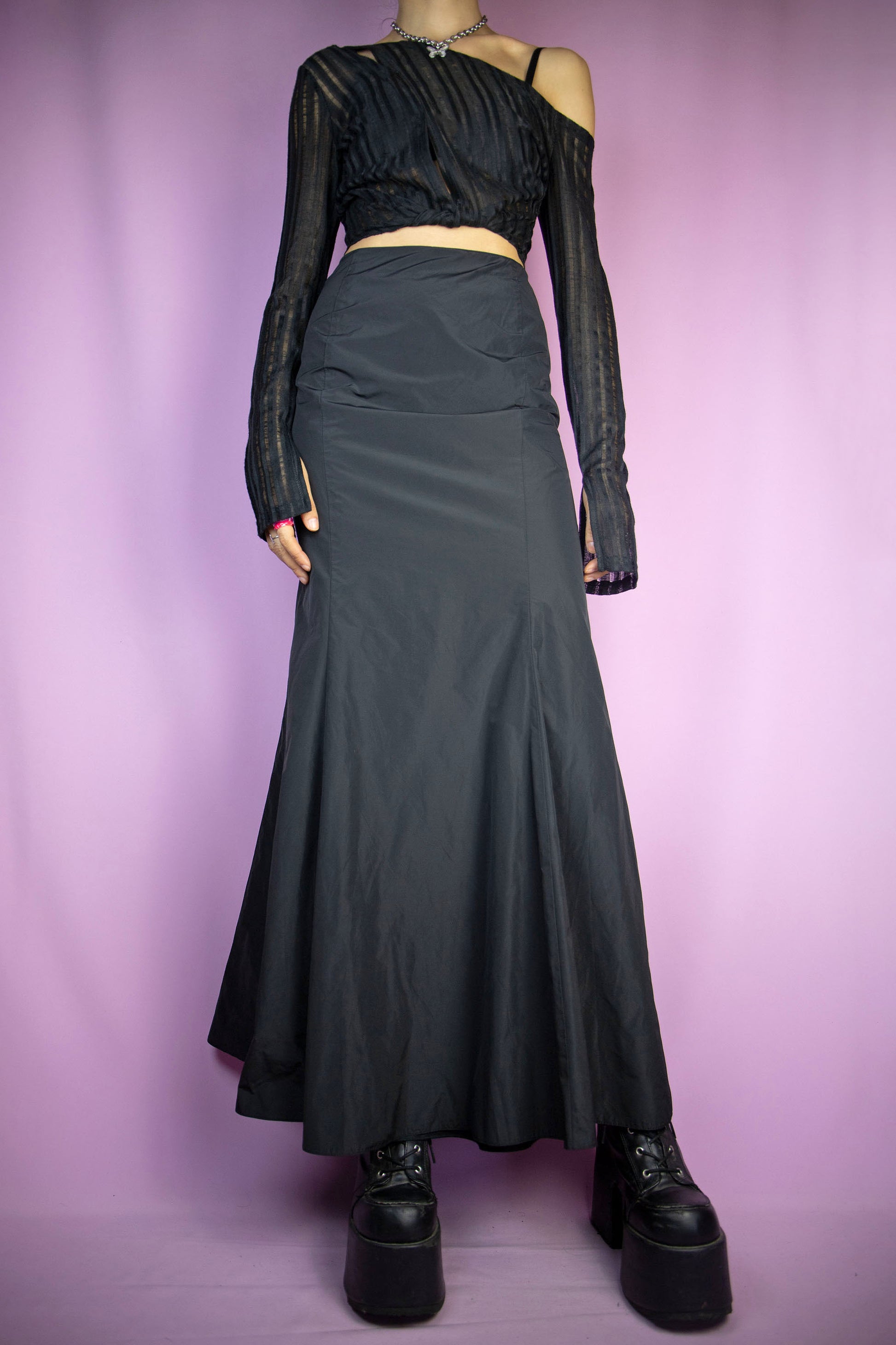 The Vintage 90's Black Mermaid Maxi Skirt is an exquisite long black skirt with a side zipper closure, perfect for cyber fairy goth party nights. This midi skirt captures the essence of 1990’s style.