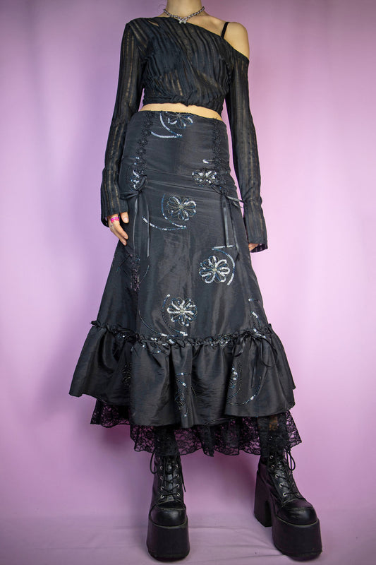 The Vintage 90s Black Trumpet Midi Skirt is an embellished skirt adorned with sequin details, bows, a ruffled hem, and a side zipper closure. Elegant fairy goth 1990s evening party maxi skirt.