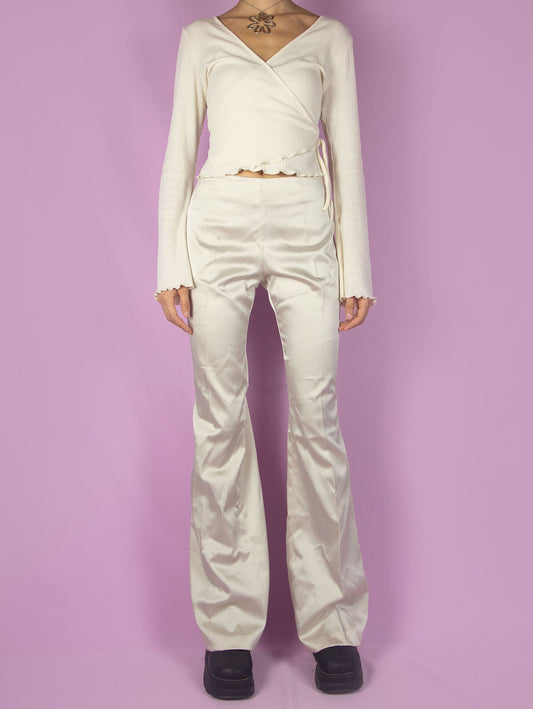 The Y2K Beige Flare Pants are vintage mid-rise shiny satin trousers, slightly elastic, with a side zipper closure. Elegant 2000s evening cocktail party trousers. Made in Italy.