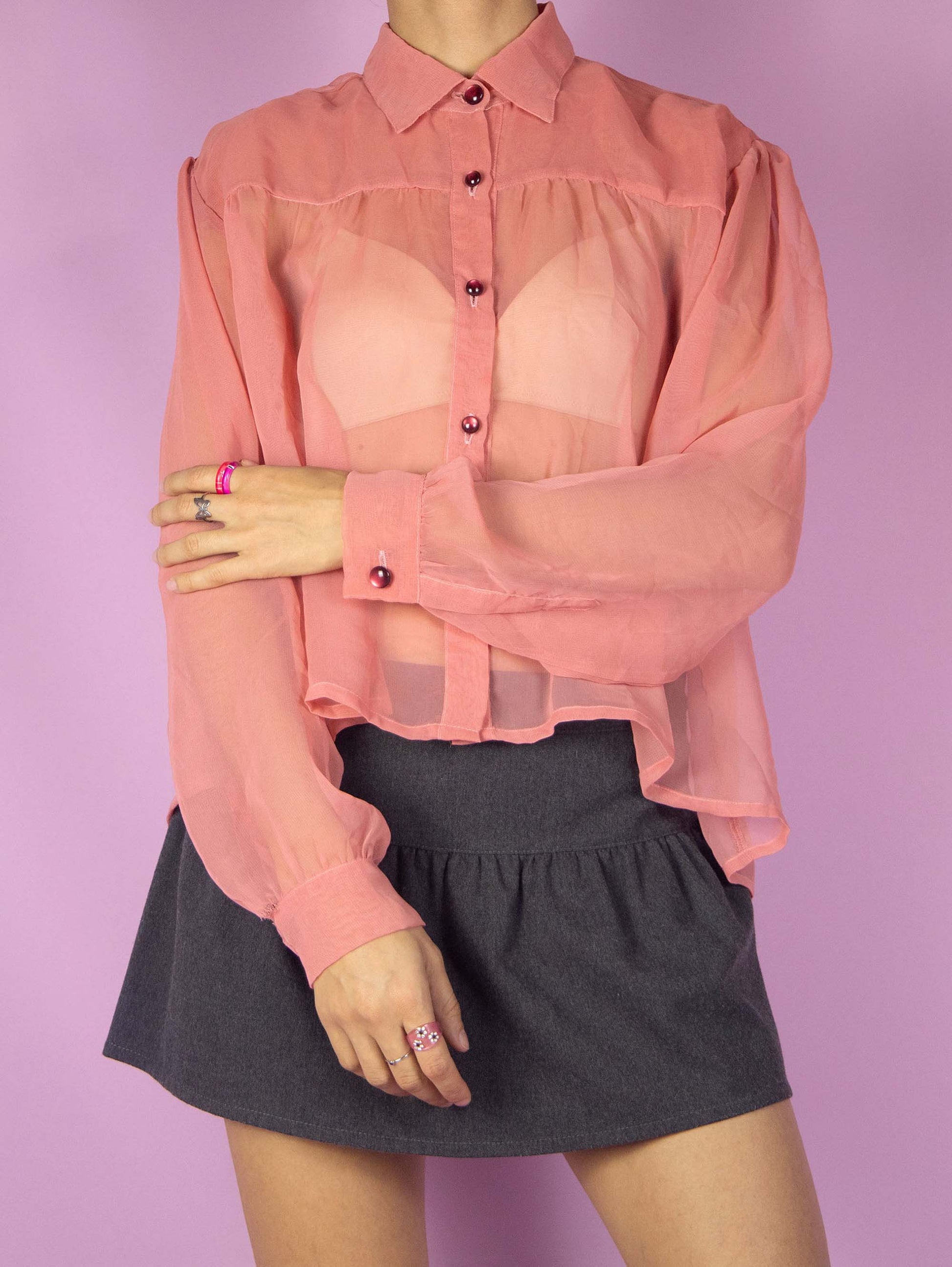 The Y2K Pink Sheer Blouse is a vintage 2000s semi-transparent romantic shirt with a collar and buttons.
