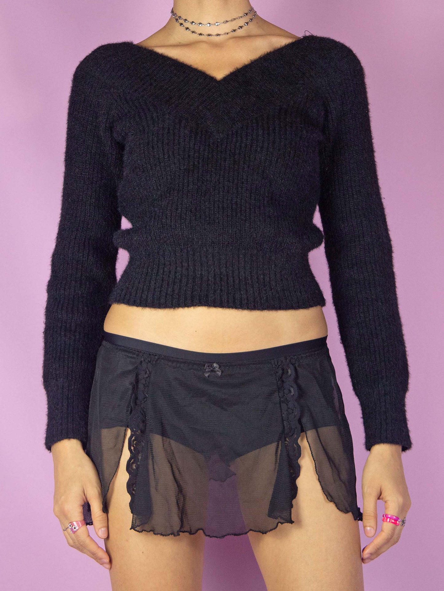 The Vintage 90s Black Mesh Slip Skirt is a semi-sheer mini skirt with side slits adorned with lace details, and an elastic waistband. Romantic 1990s lingerie micro skirt.
