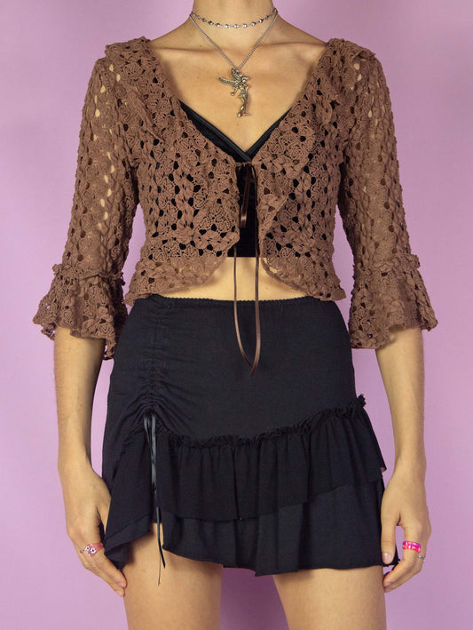 The Y2K Brown Ruffle Bolero Jacket is a vintage 2000s boho fairy inspired crochet knit tie front cropped blouse with bell sleeve and ruffled neckline.