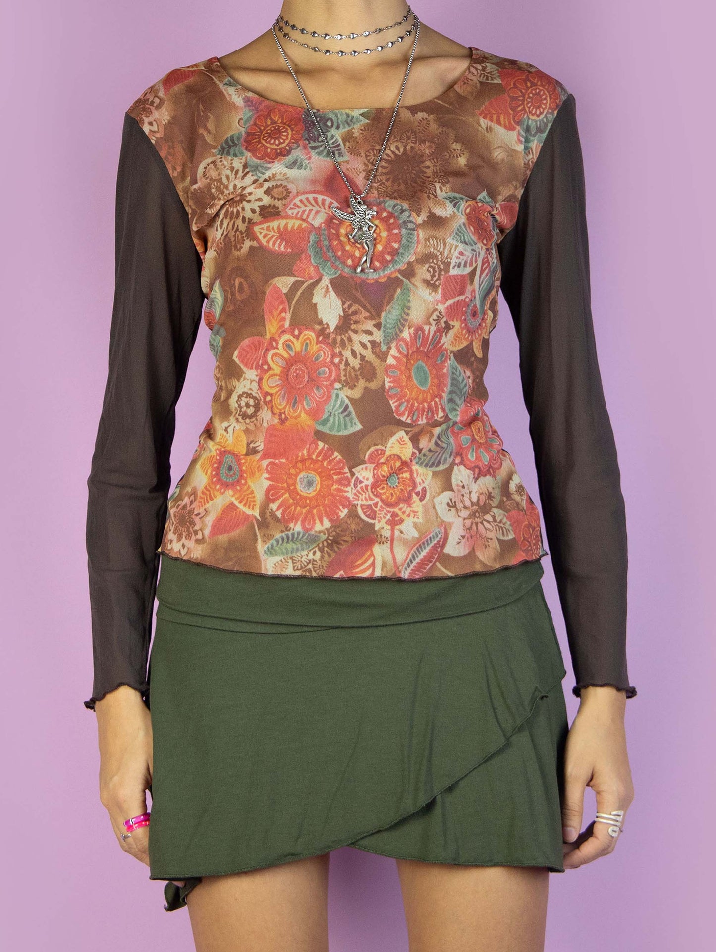The Y2K Brown Mesh Graphic Top is a vintage long-sleeved semi-sheer mesh shirt with a multicolored abstract floral print on the front. Super cute fairy grunge 2000s subversive top.
