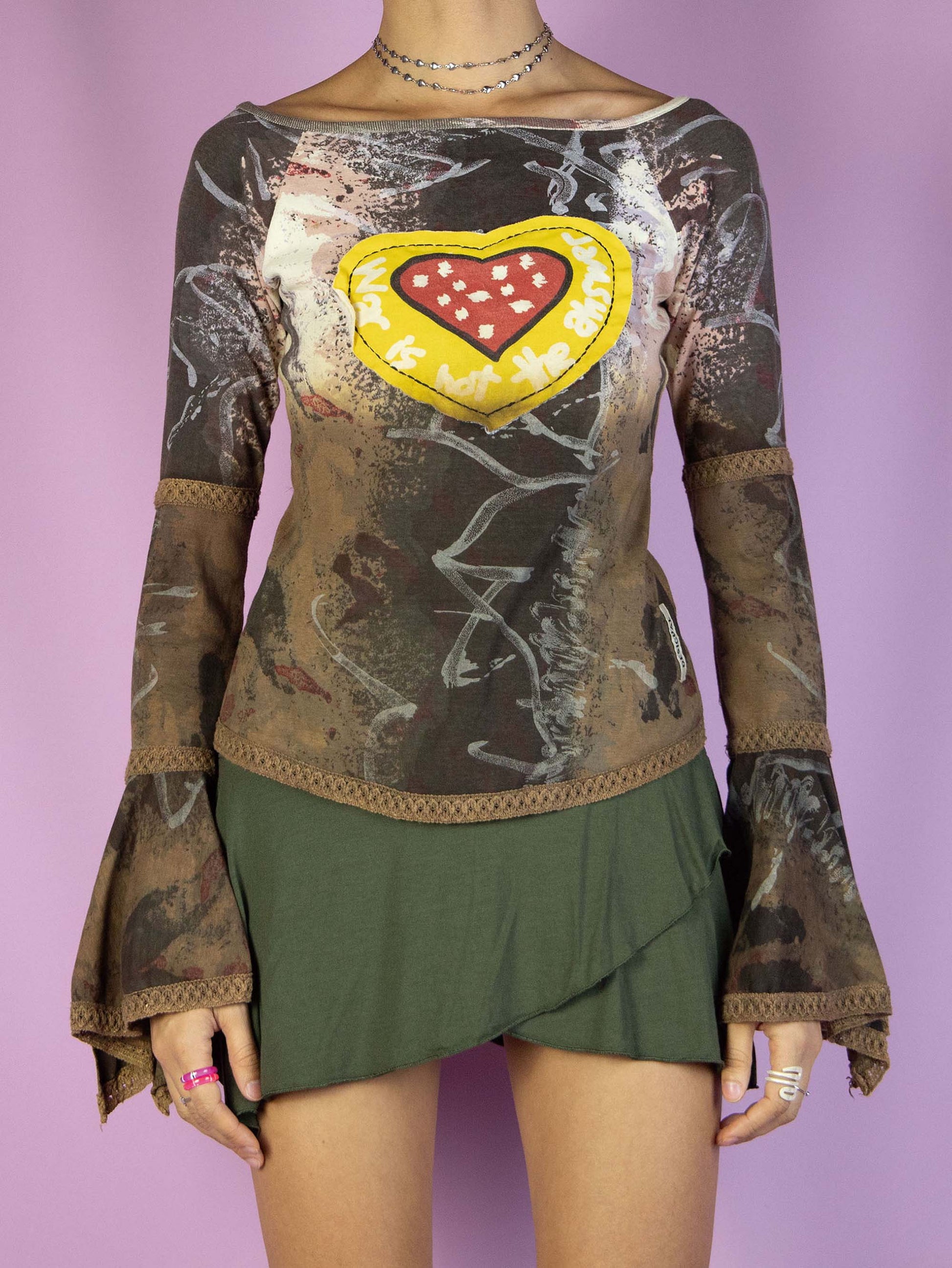 The Y2K Desigual Brown Bell Sleeve Top is a multicolored graphic brown shirt with an abstract print, long bell sleeves, and a heart-shaped patchwork-style detail. Cyber avant garde 2000s subversive top.