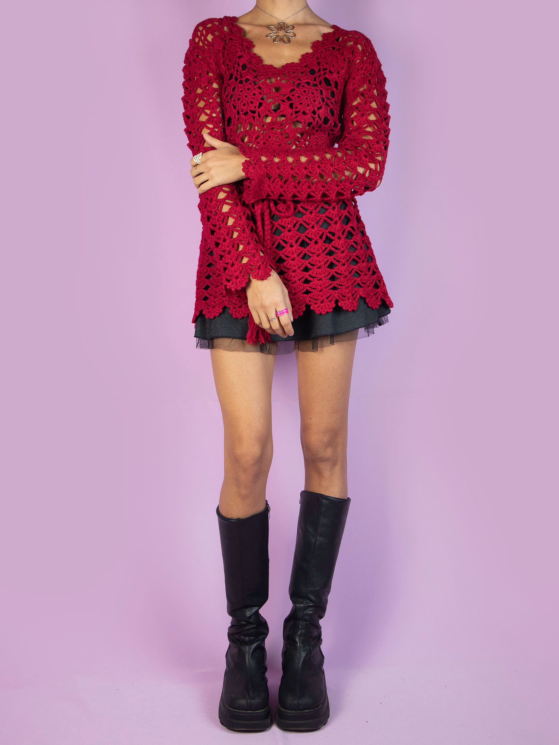 The Y2K Red Crochet Knit Sweater is a red crocheted knit top that ties at the waist and is made from a wool blend. Stunning romantic coquette boho 2000s pullover.