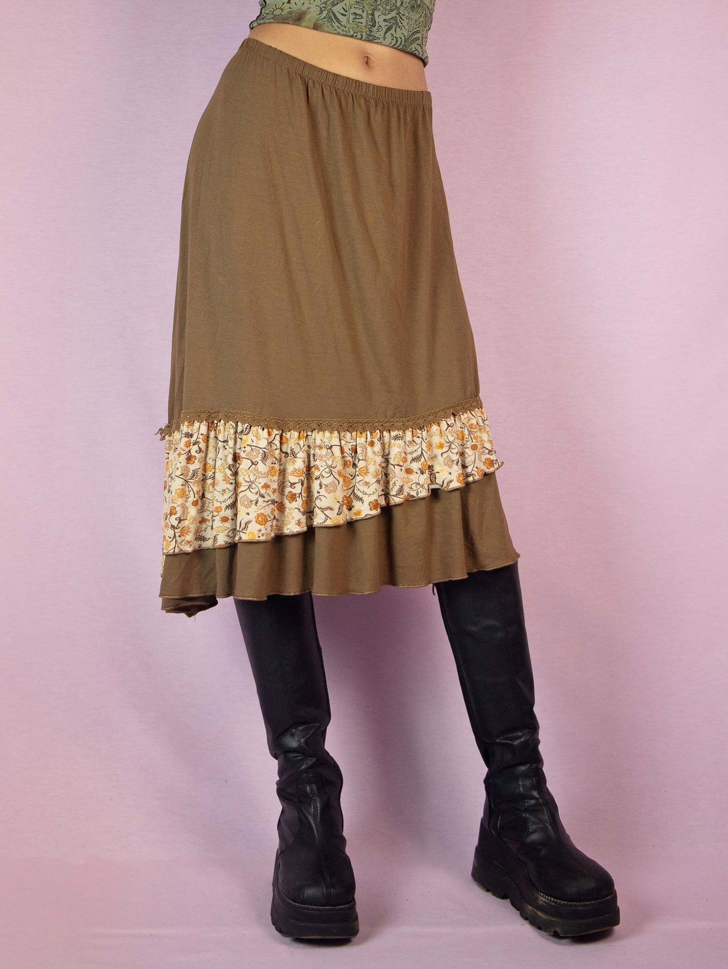 The Y2K Asymmetric Brown Midi Skirt is a vintage 2000s fairy grunge cottagecore style skirt with an asymmetric floral print ruffle hem and elastic waist.