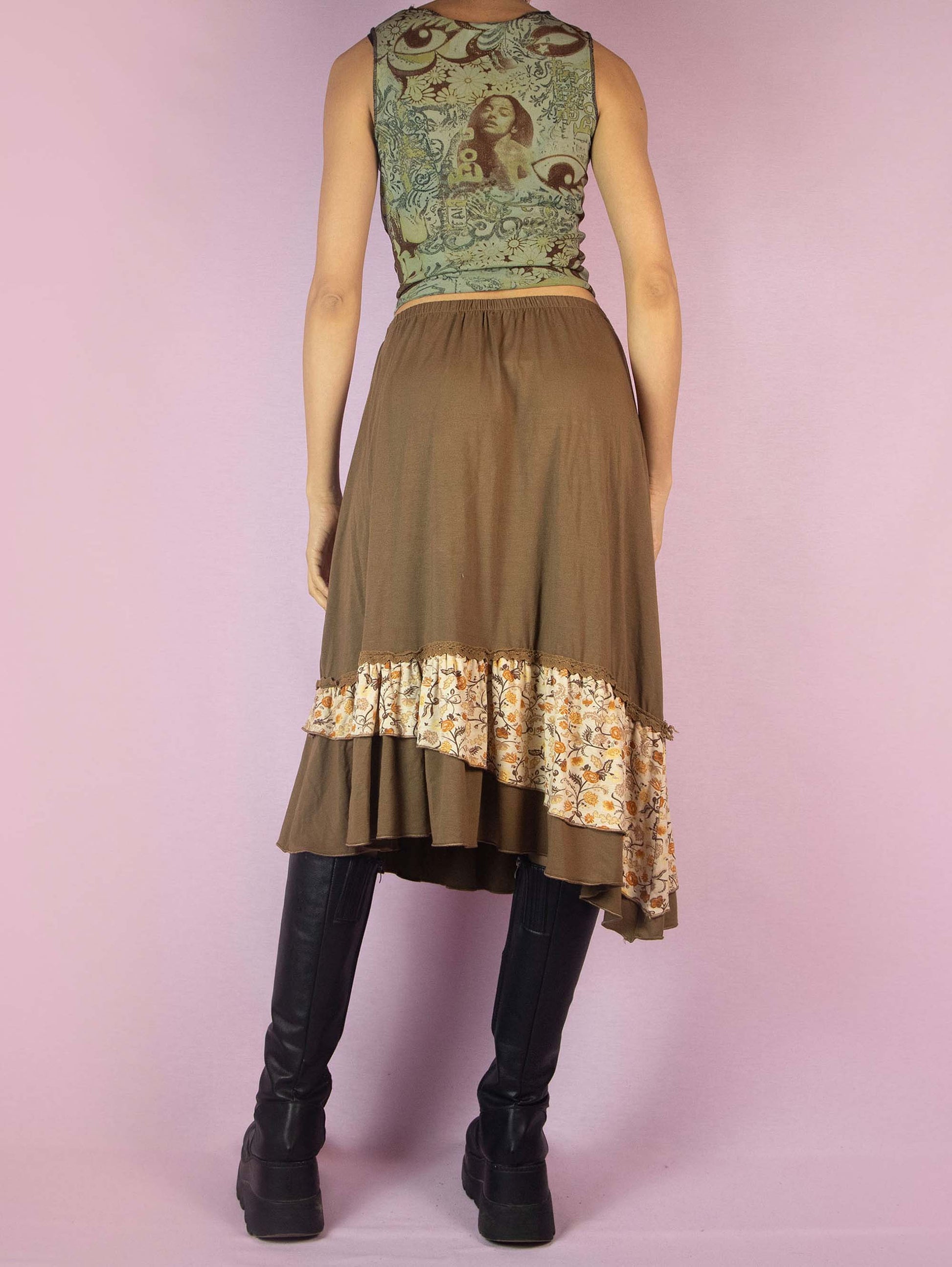 The Y2K Asymmetric Brown Midi Skirt is a vintage 2000s fairy grunge cottagecore style skirt with an asymmetric floral print ruffle hem and elastic waist.