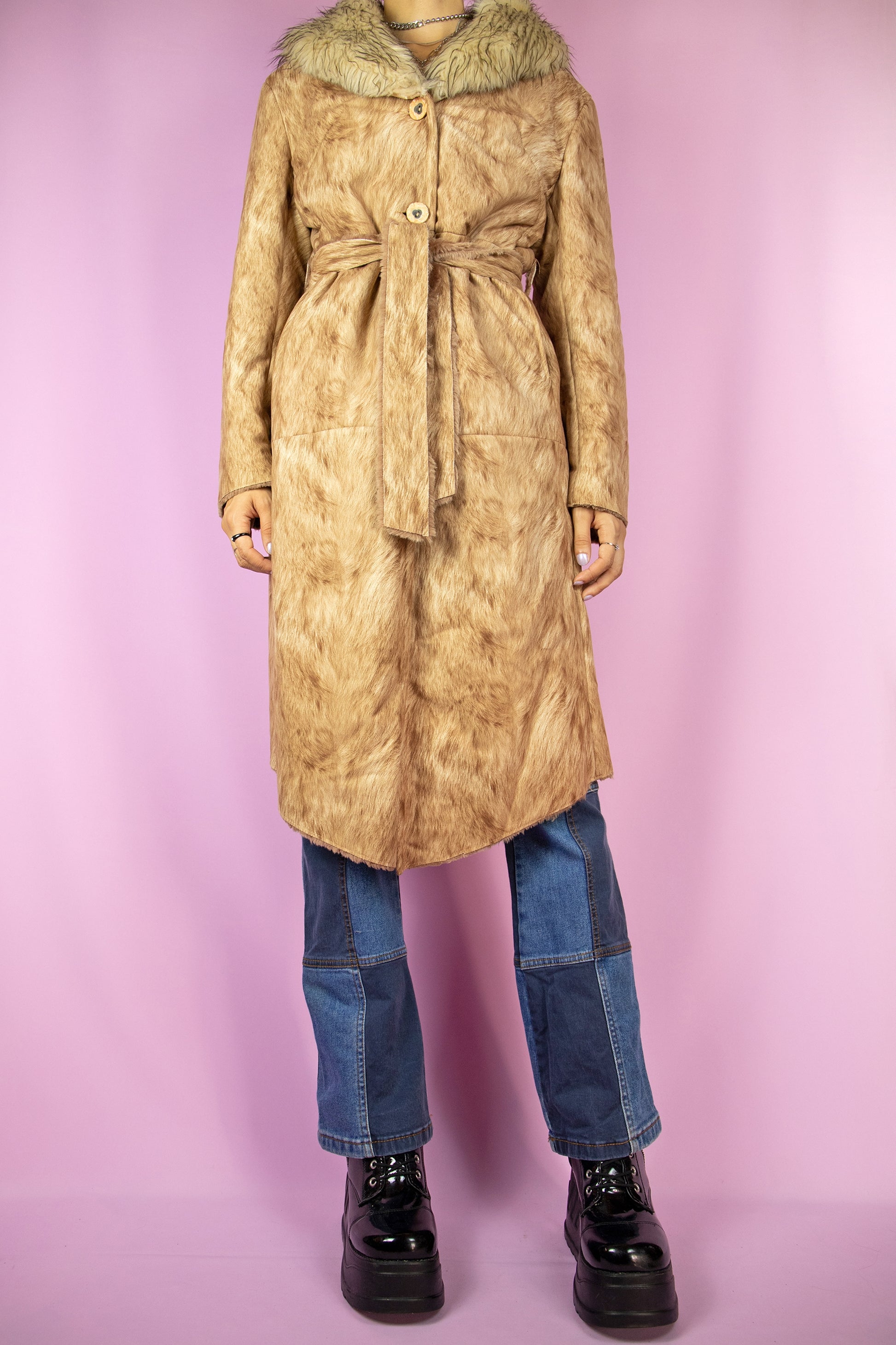 The Y2K Brown Faux Fur Long Coat is vintage abstract graphic printed maxi jacket featuring a faux fur collar, pockets, button closure, and a matching belt. Cyber 2000s penny lane winter statement coat.