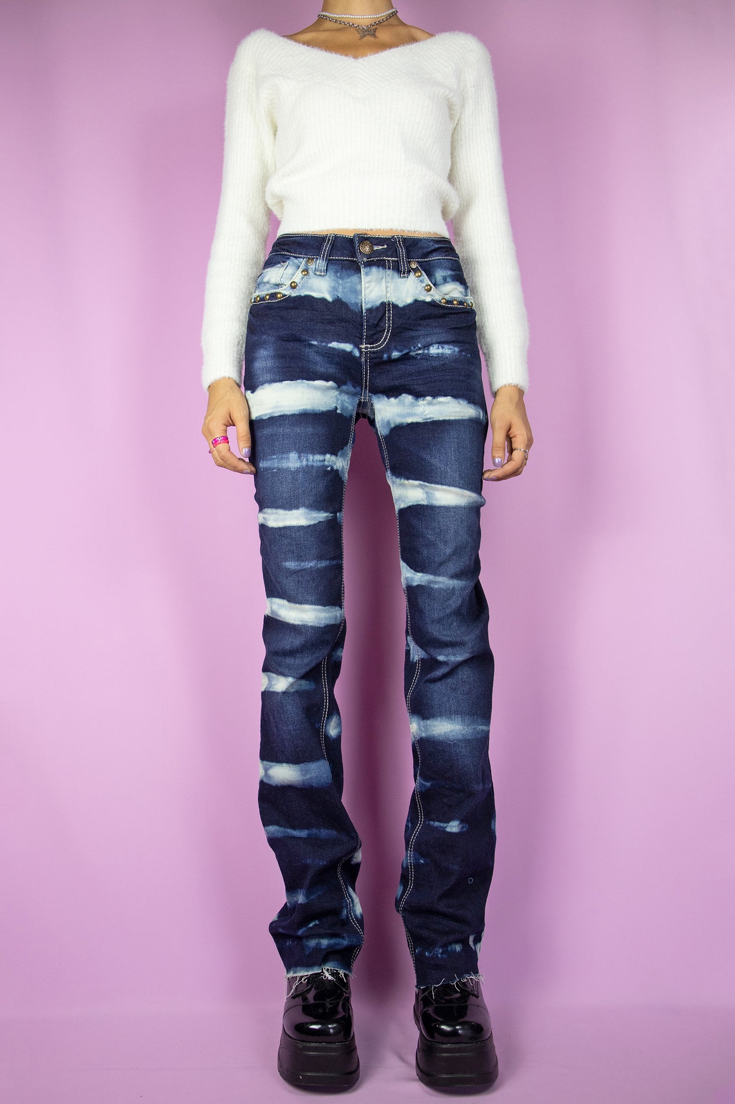 The Vintage Y2K Striped Bleach Jeans are straight stretch denim pants adorned with bleached stripes, featuring pockets and a raw hem. These iconic millennium cyber custom jeans from the 2000s are the perfect choice for festivals, raves, and clubbing.